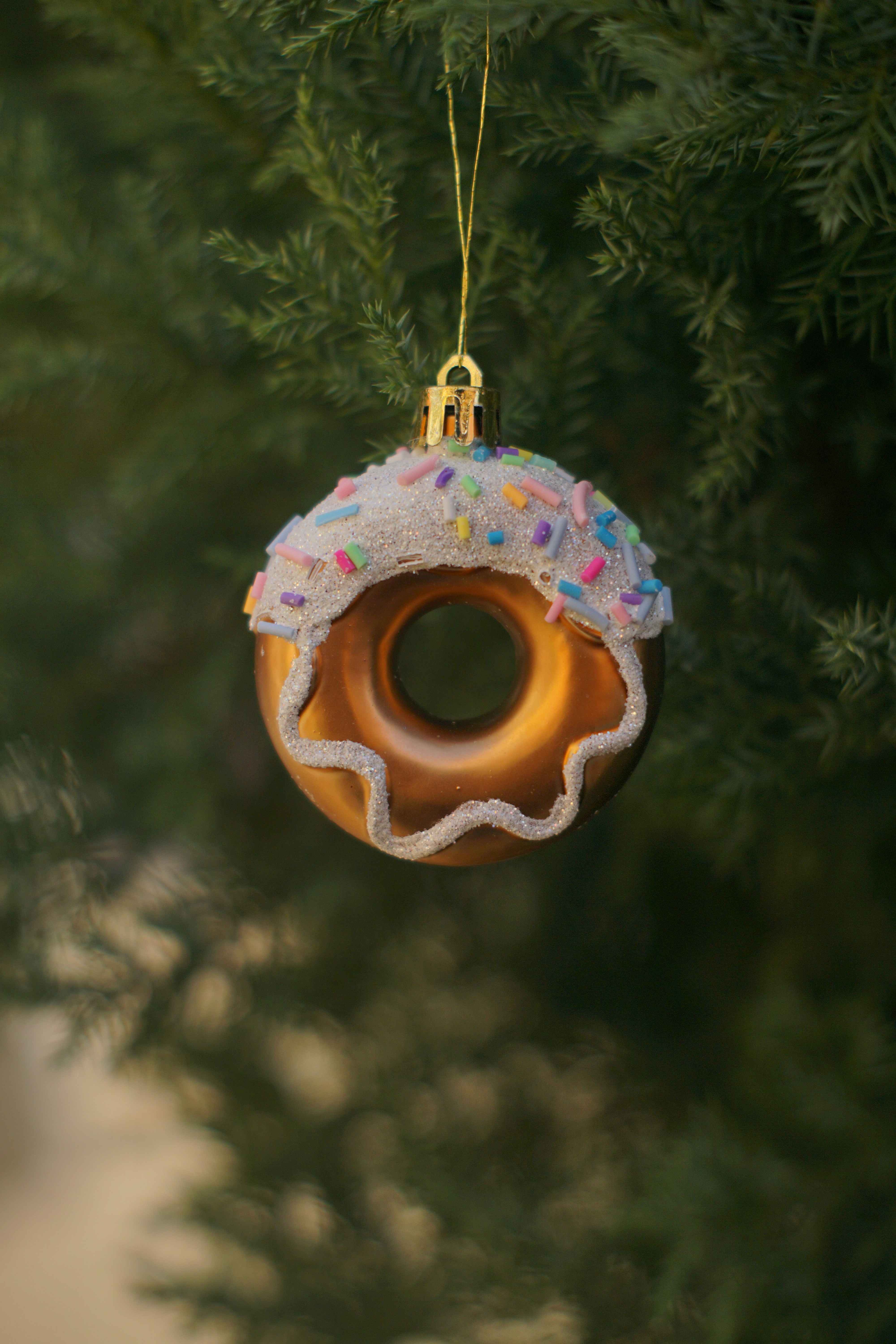 Donut ornament hanging on a christmas tree