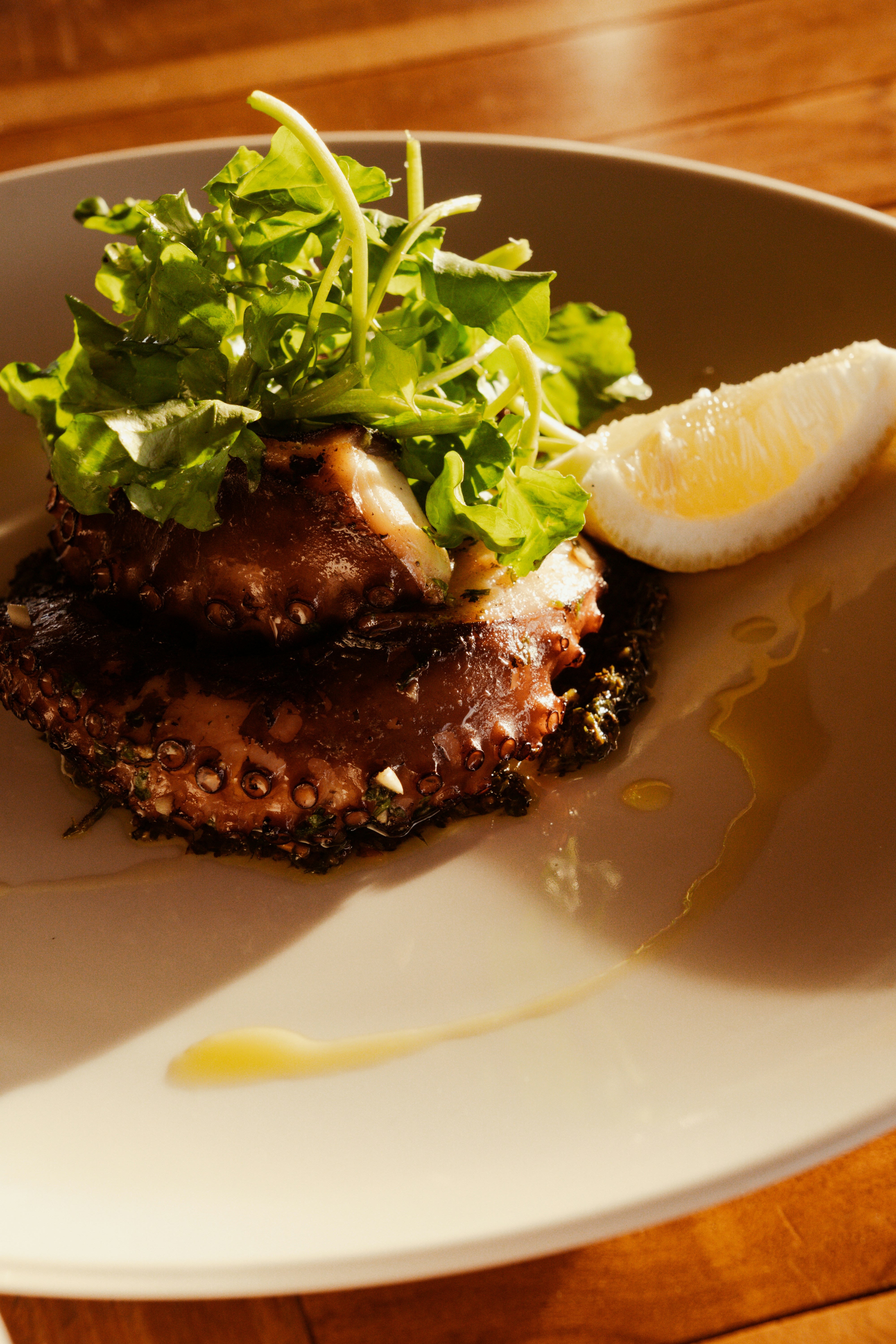 Grilled octopus with arugula and lemon slice