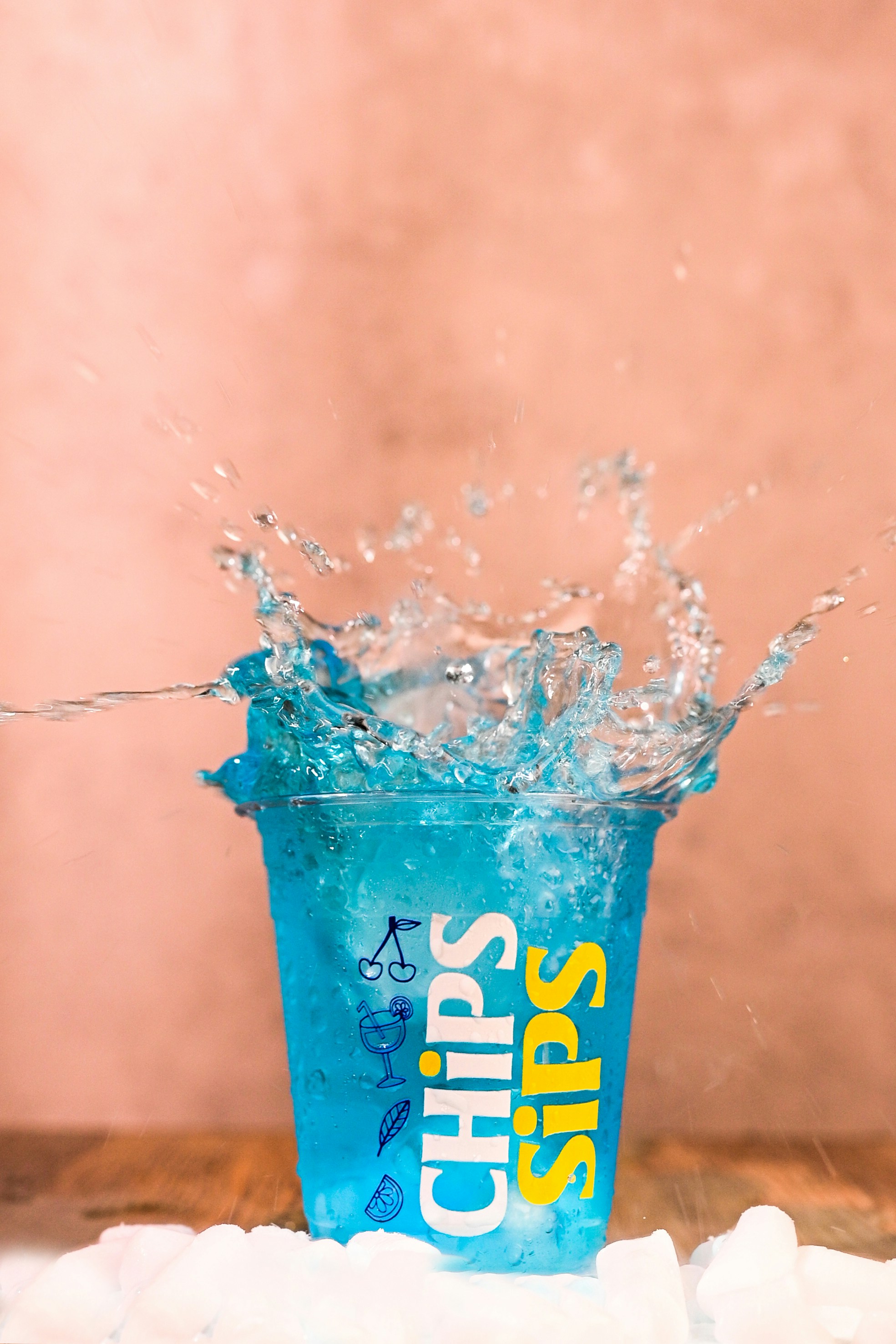Blue drink splashing in a cup with ice