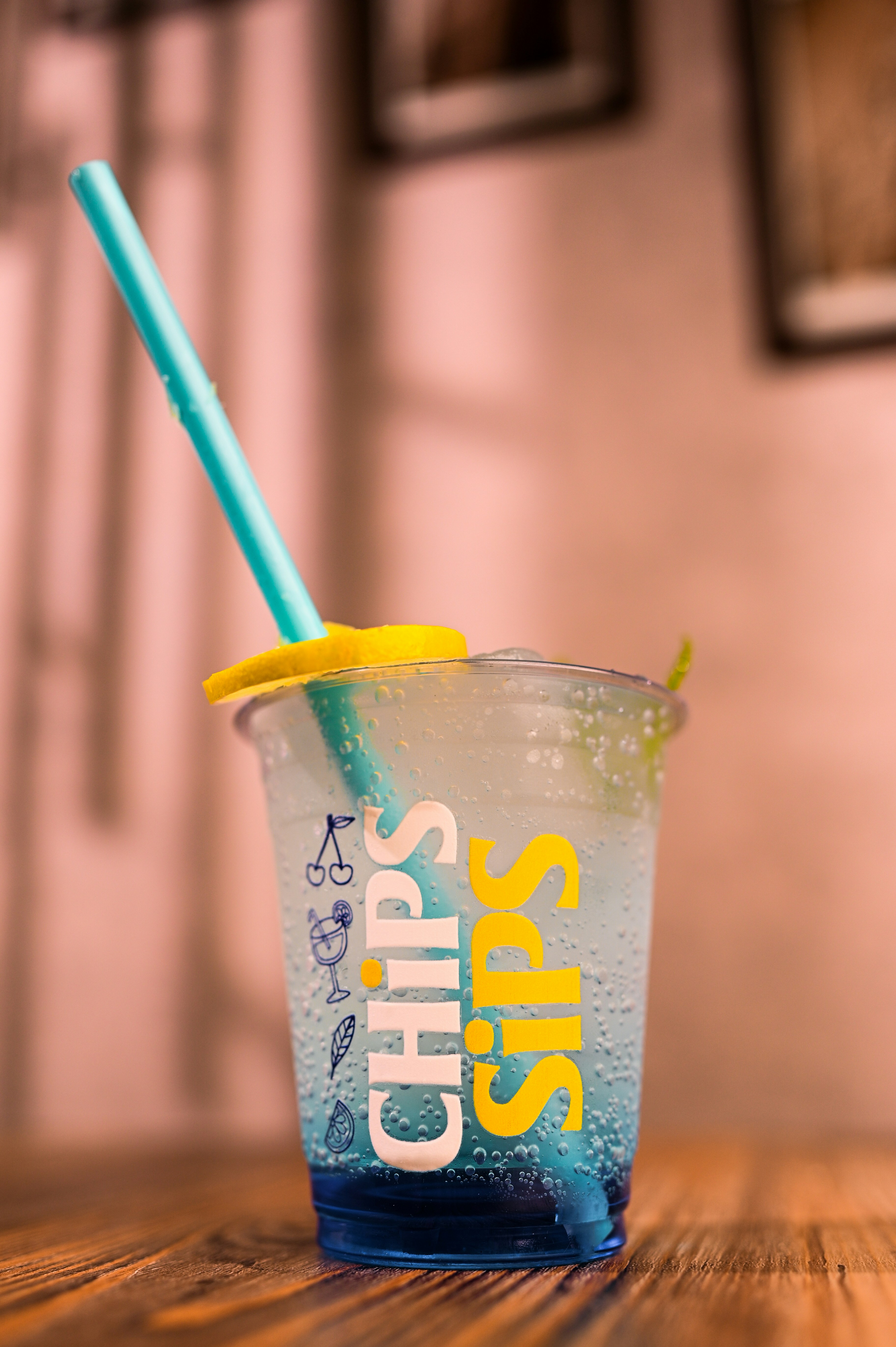 A refreshing drink with a blue straw and lemon slice.