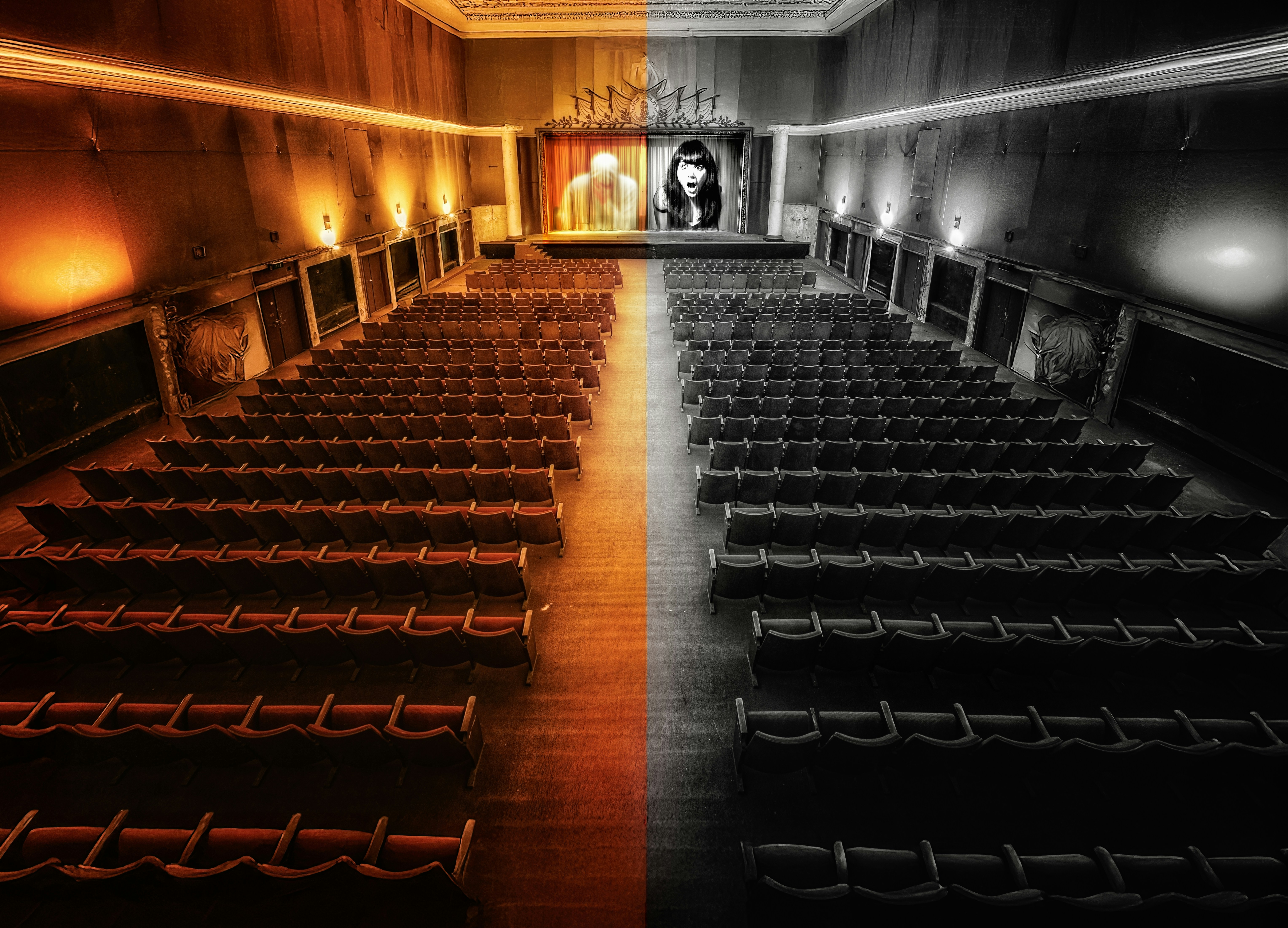 Teatro vuoto con uno schermo che mostra un volto.