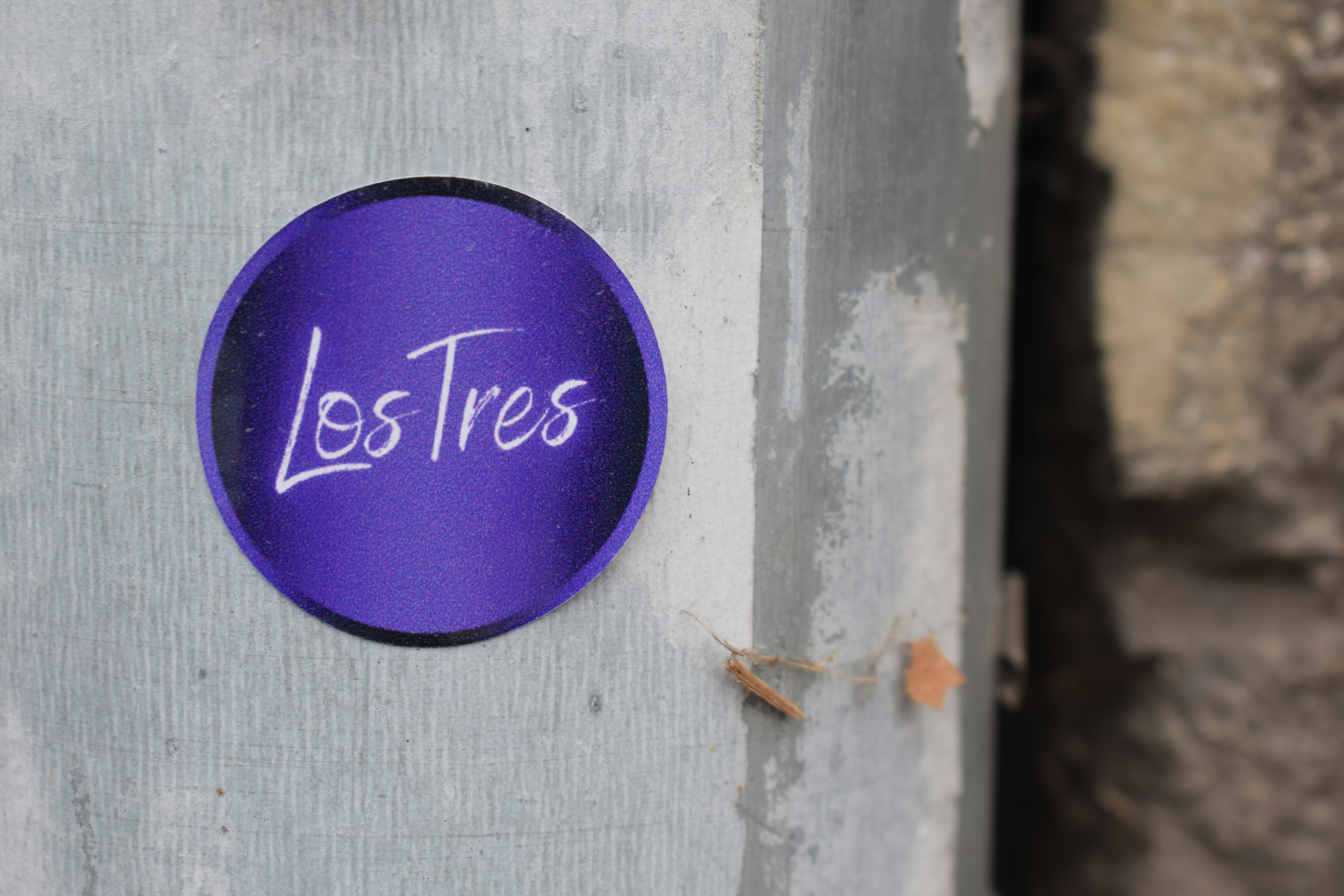 Purple circular sticker with los tres text