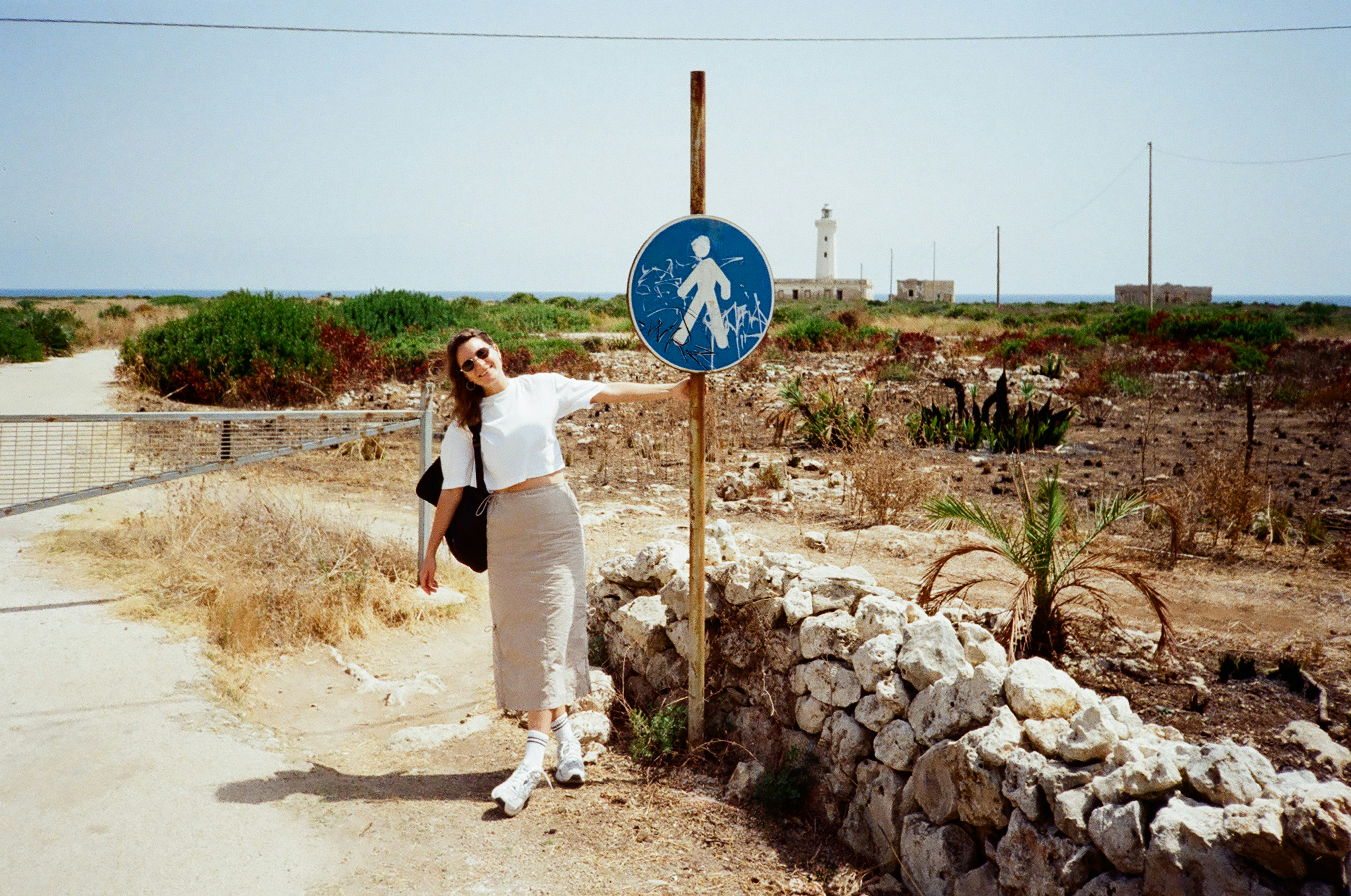 Woman standing by a pedestrian crossing sign
