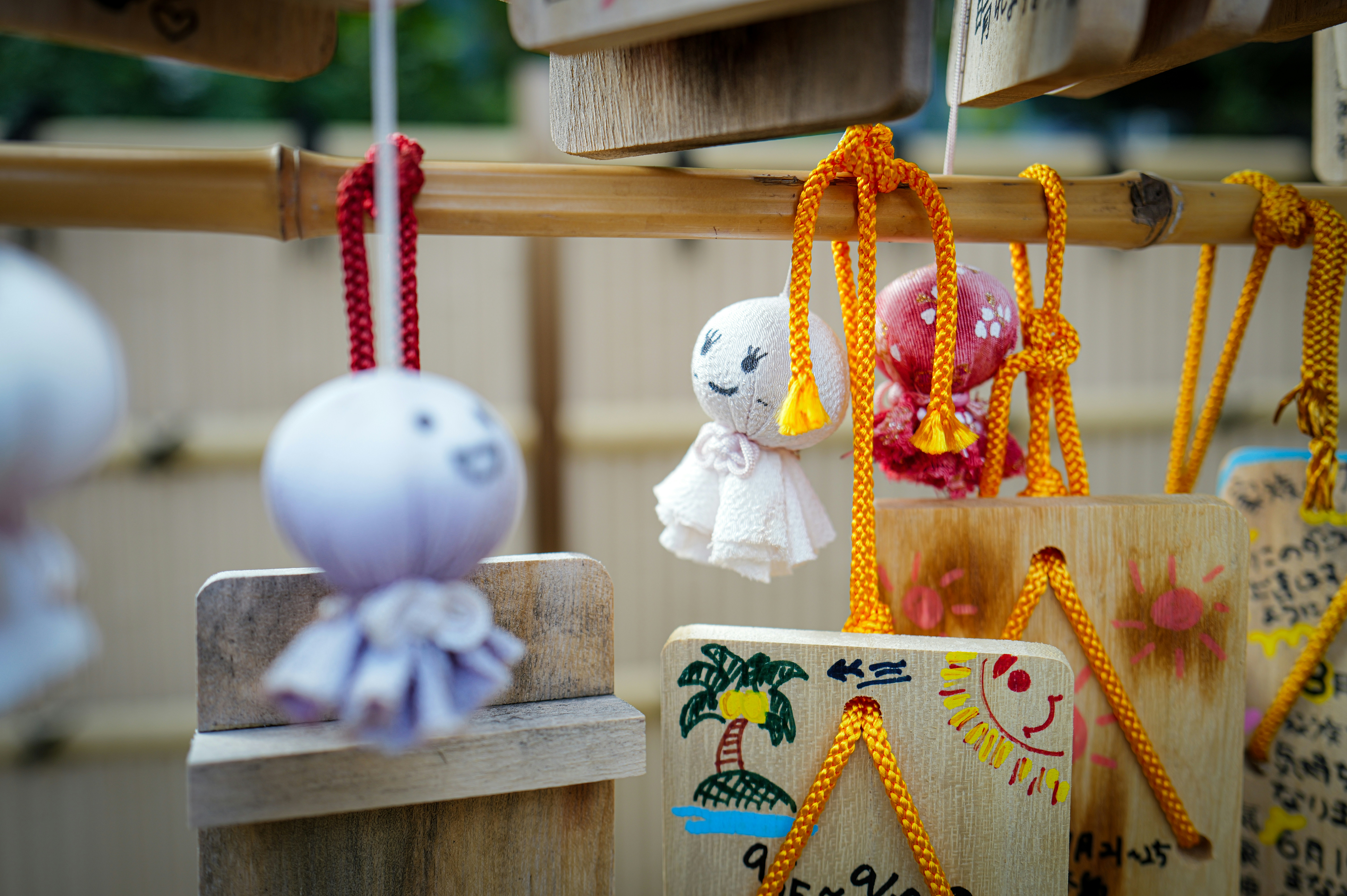Japanese teru teru bozu dolls hanging on a rack.