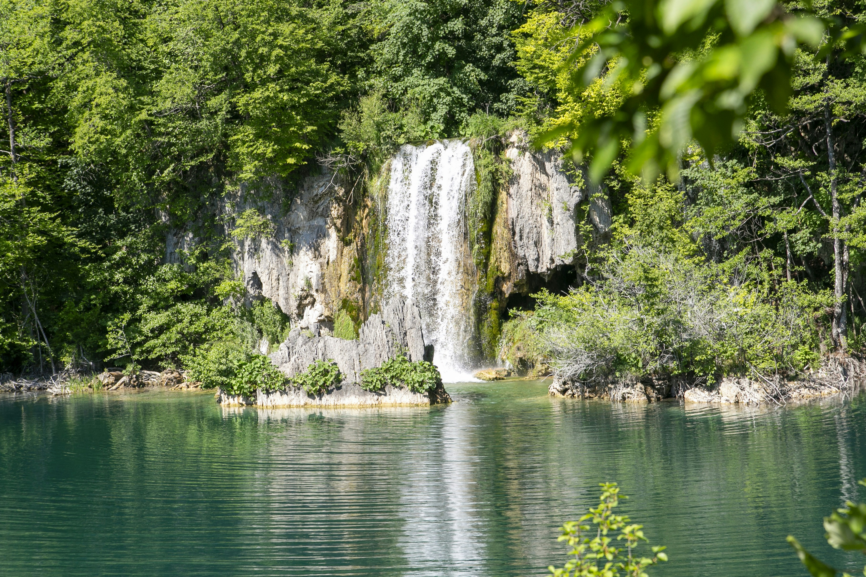 Waterfall cascading into a serene turquoise lake