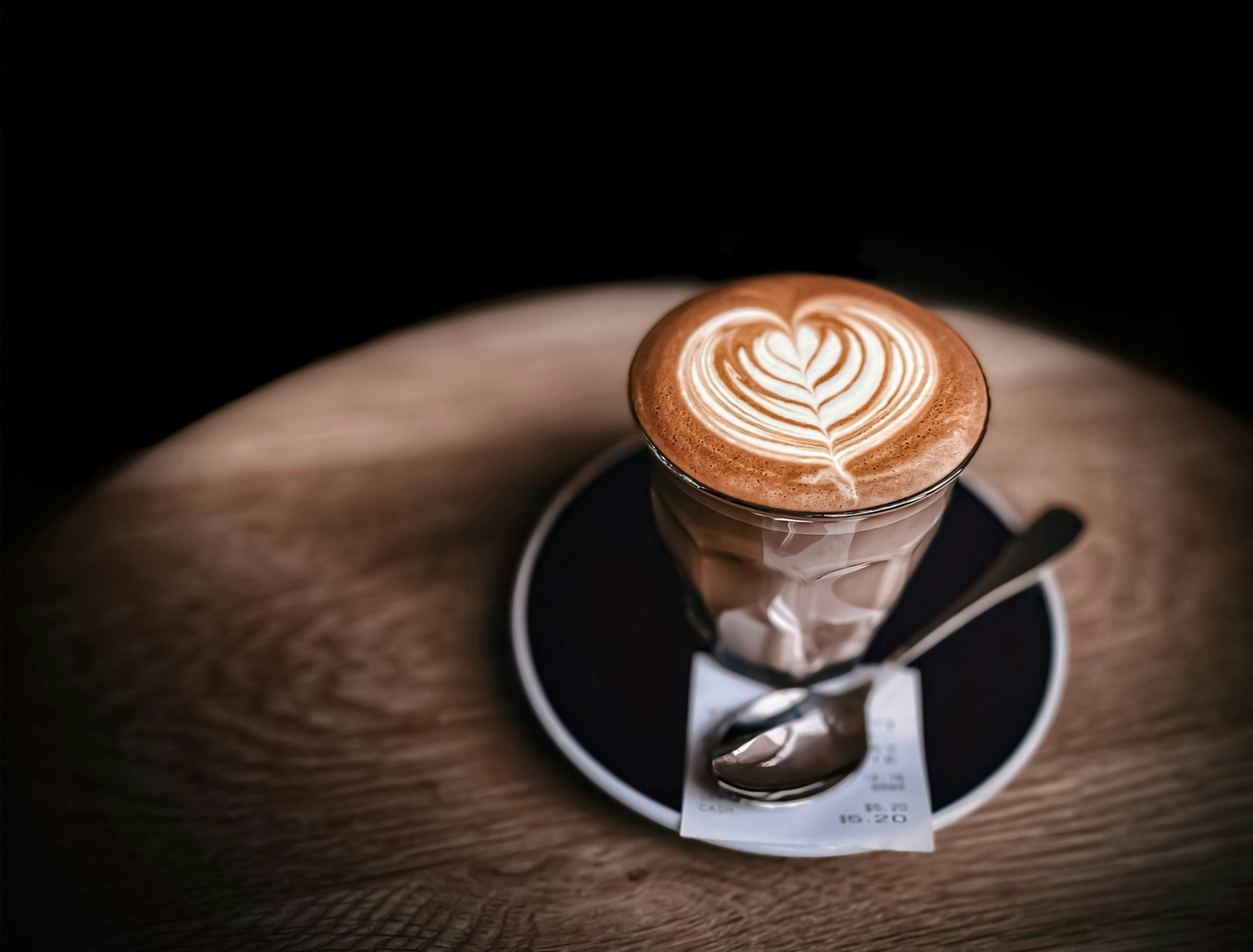 Latte art in a glass on a saucer