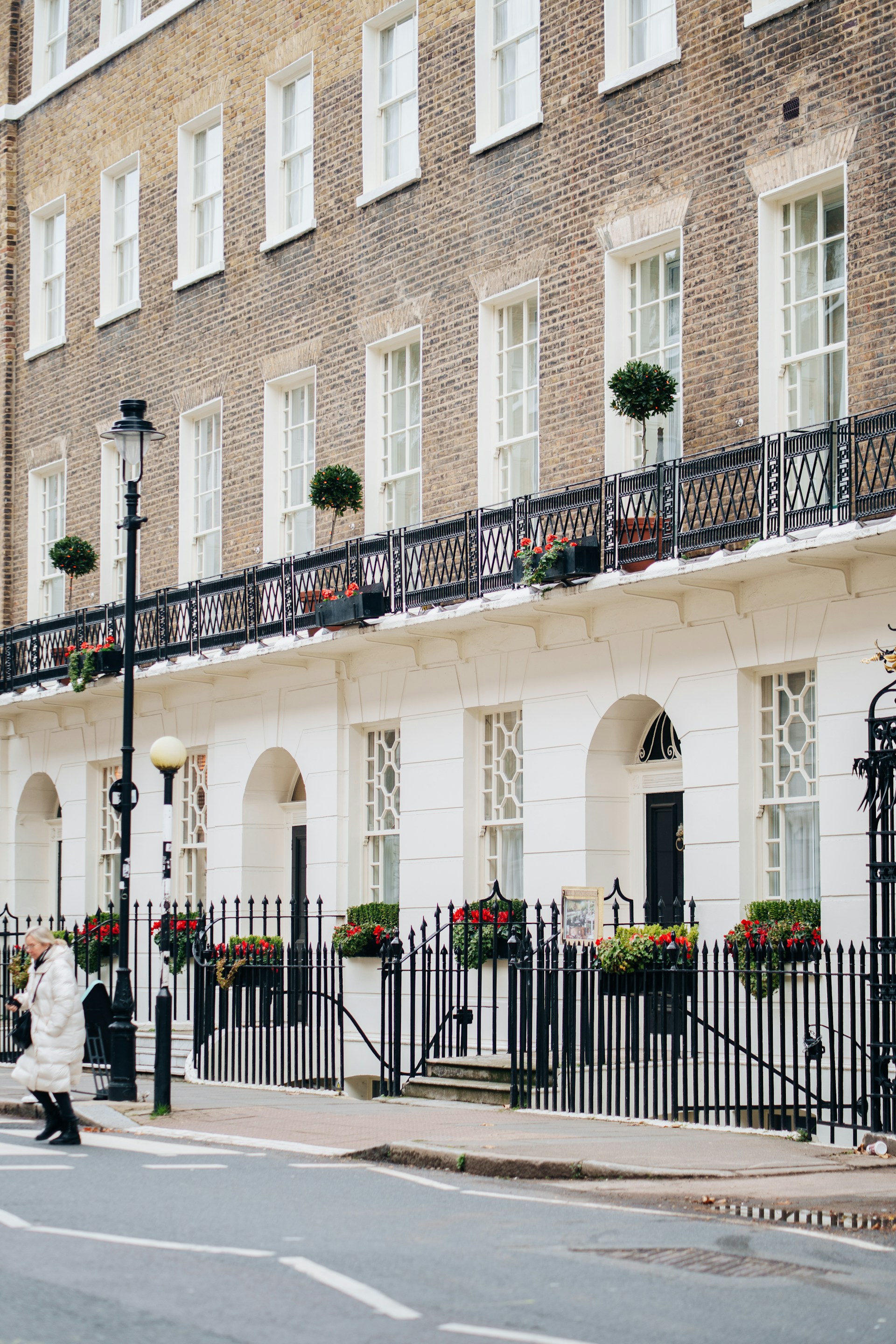 Elegant georgian townhouses with ornate balconies and flowers.
