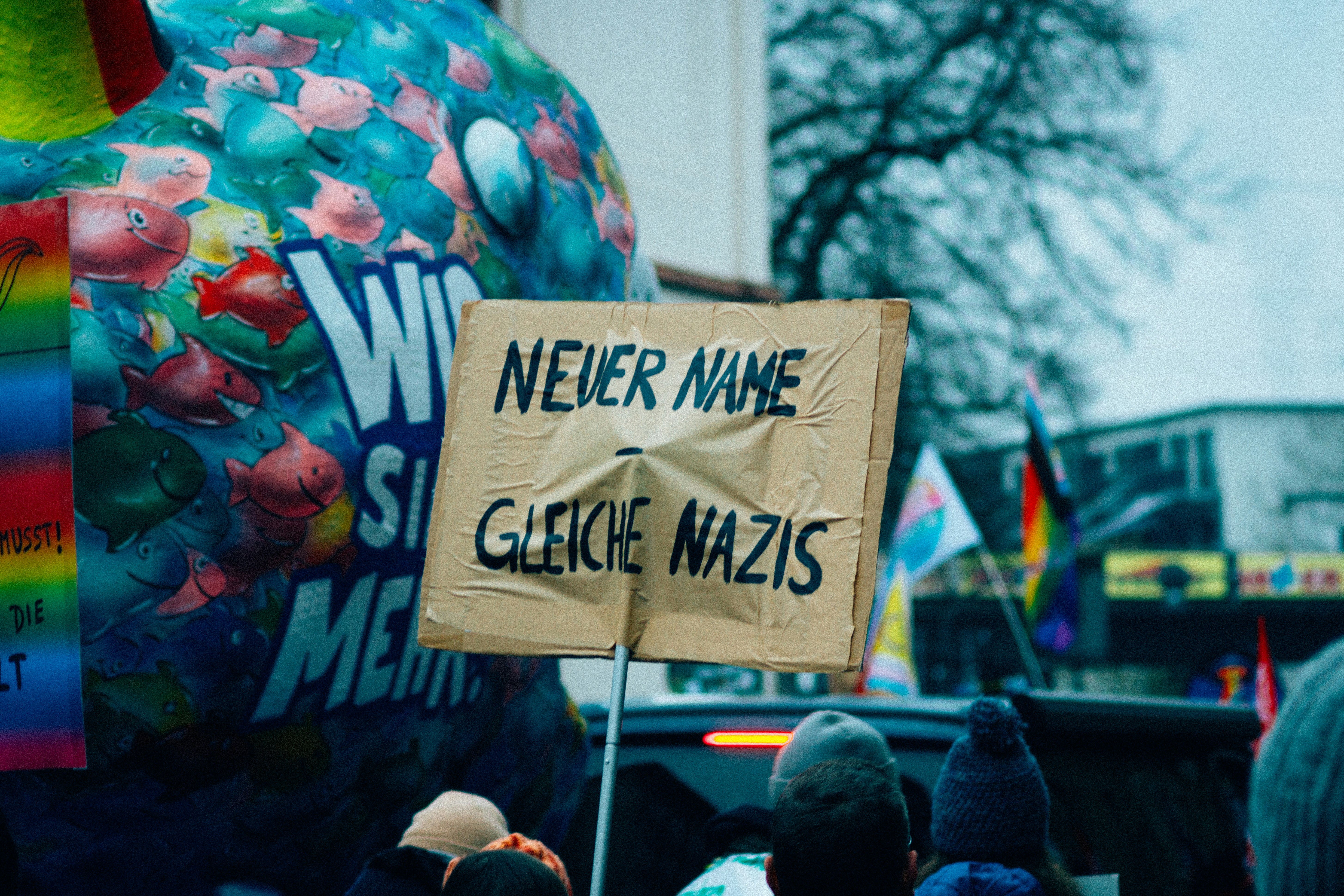 Protesters hold sign saying "never name same nazis"
