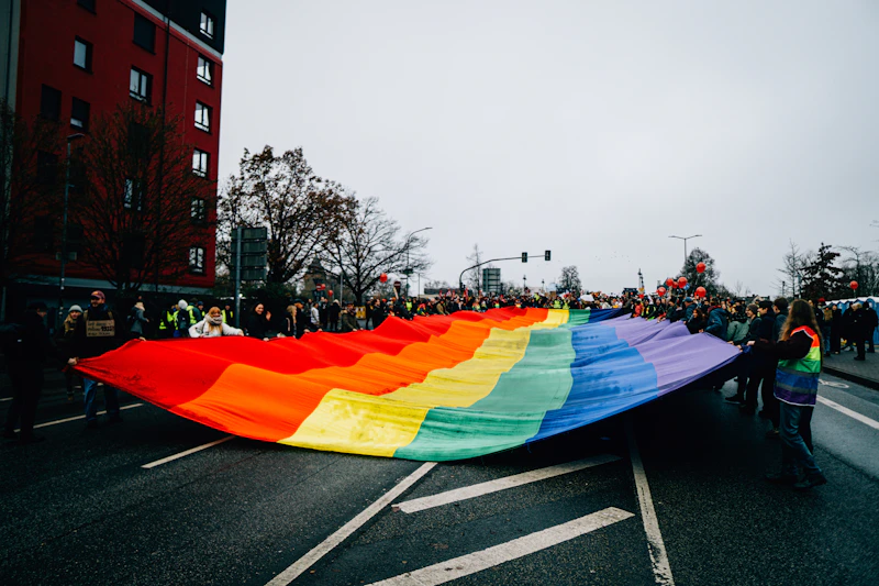 Community proudly carrying a large rainbow flag