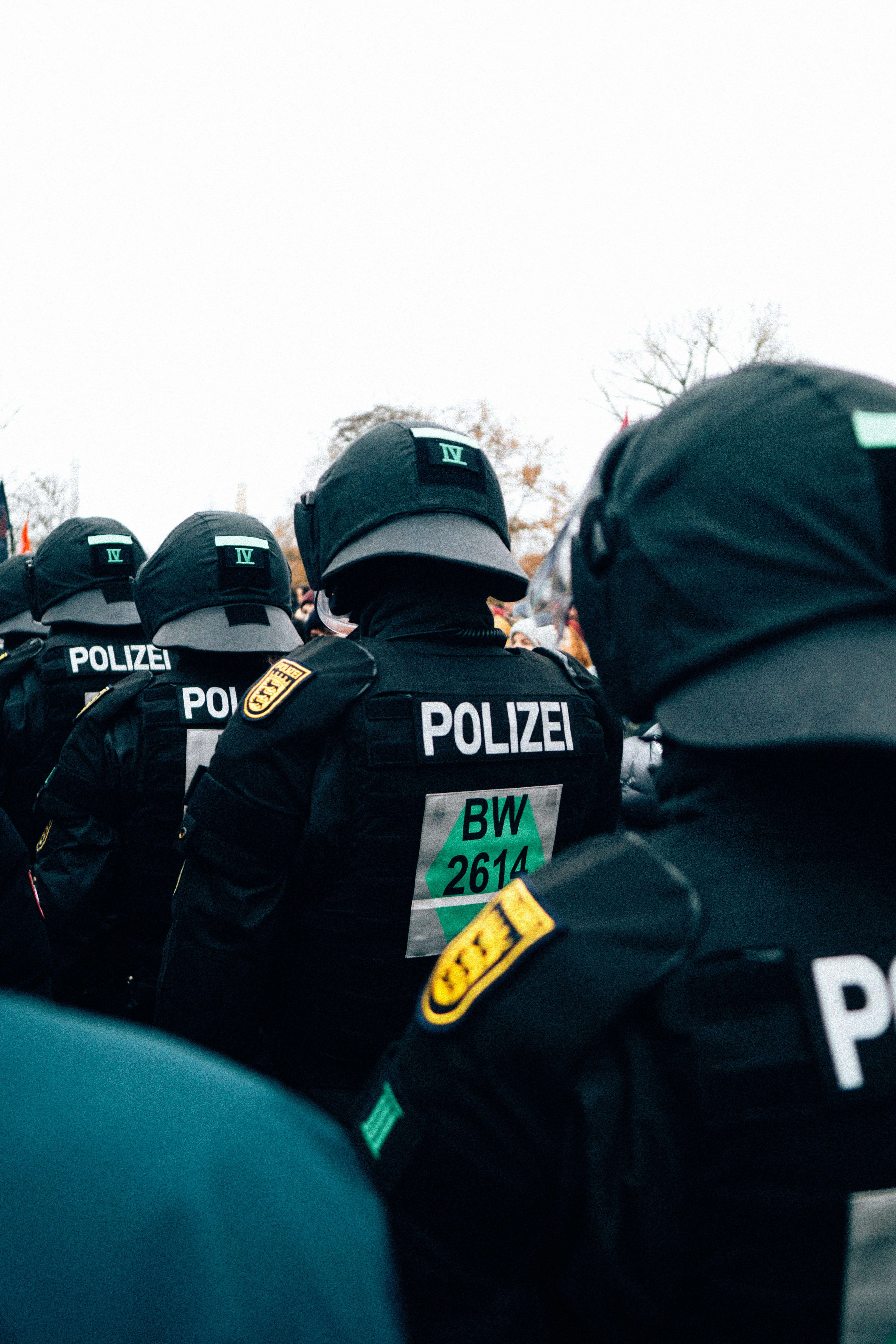 Police officers in riot gear stand in formation.