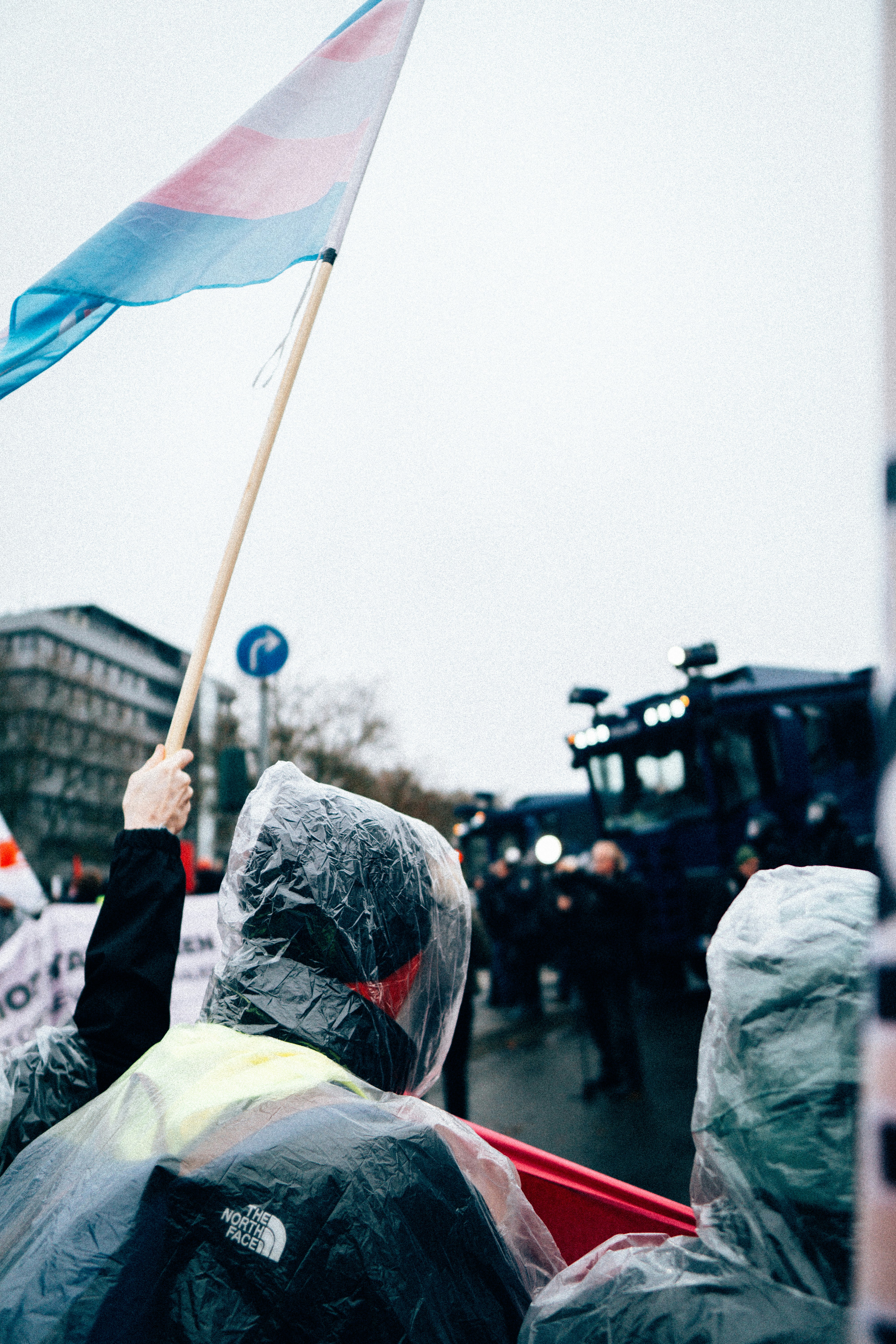 Protesters in plastic ponchos holding a flag