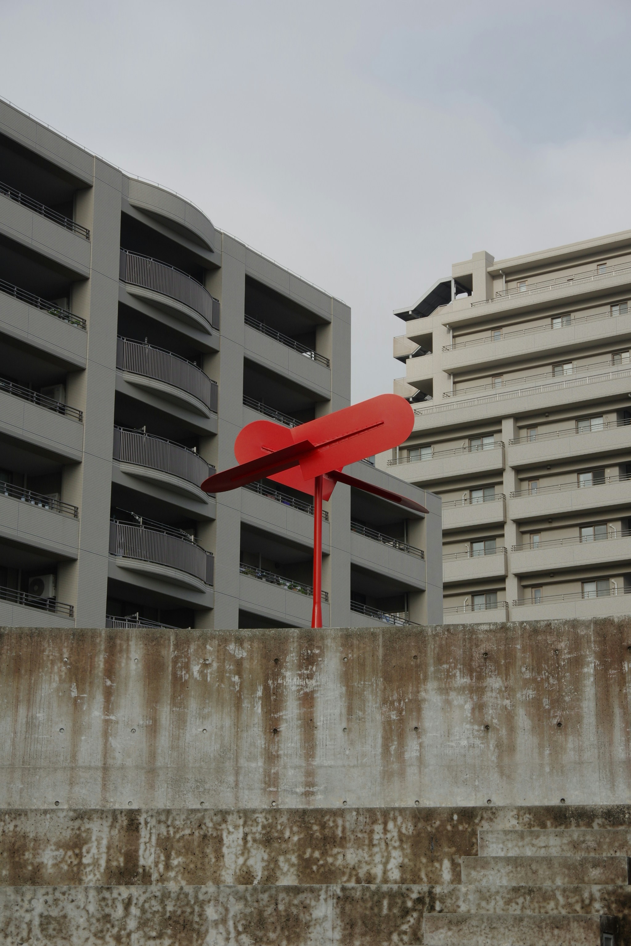 Patung merah di depan gedung apartemen