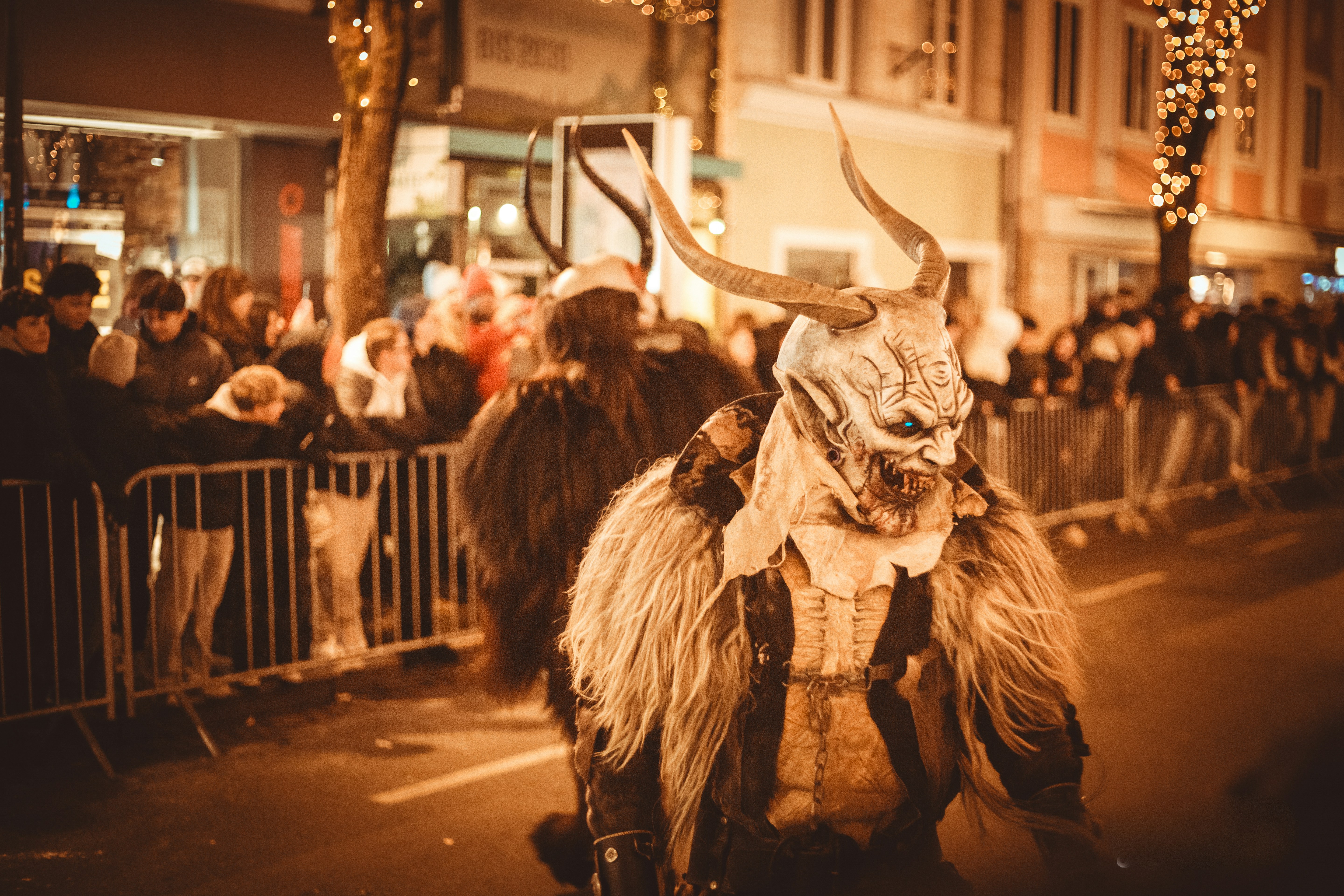 Menschen in Krampus-Kostümen während einer nächtlichen Parade