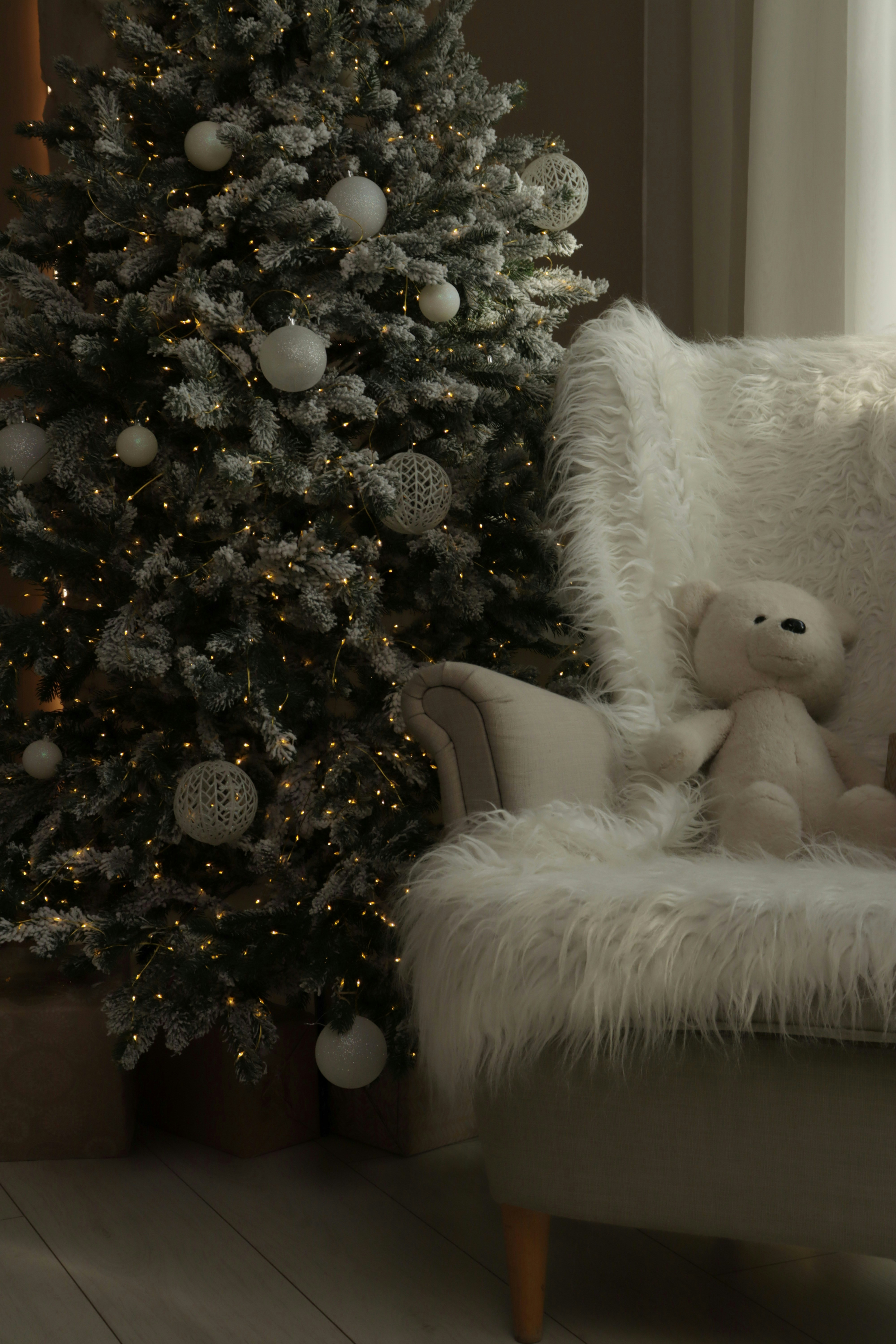 Decorated christmas tree and teddy bear on chair