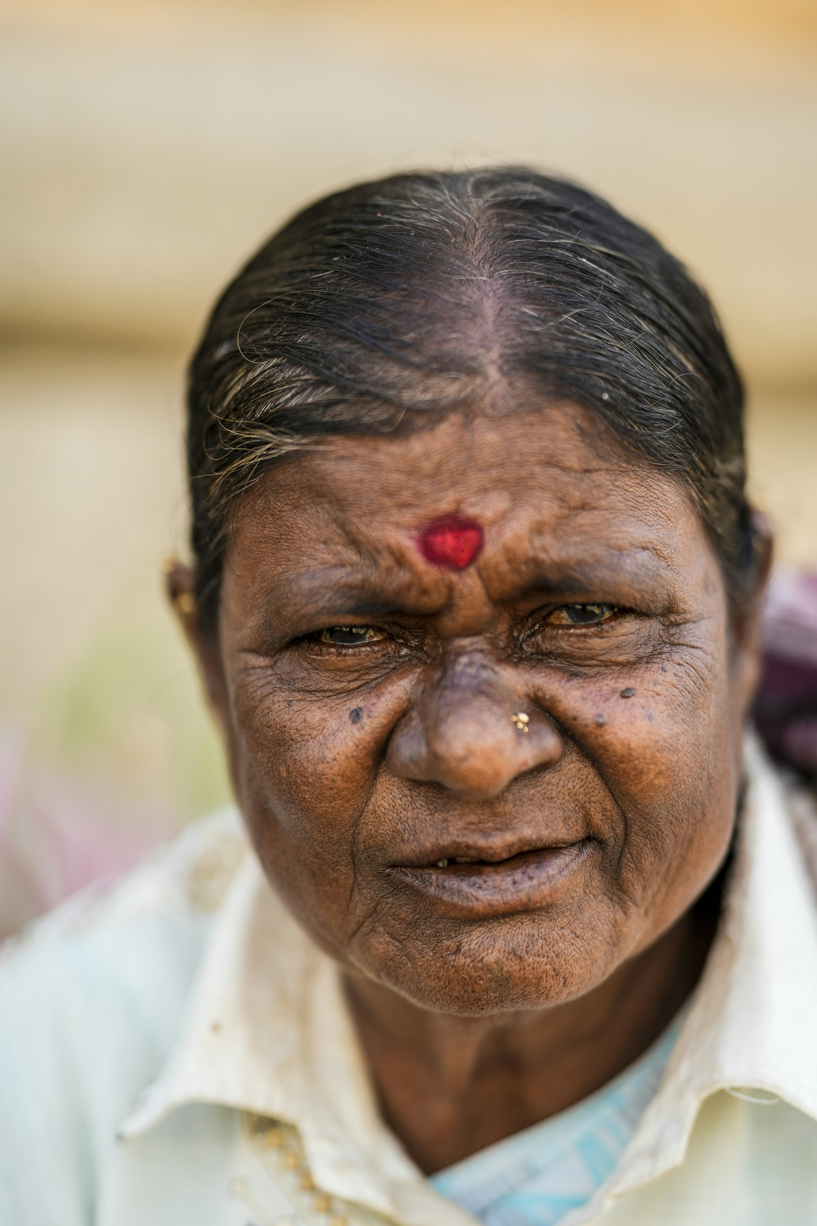 Elderly woman with a red bindi on her forehead.
