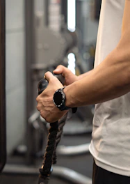 Man's hands gripping a cable machine handle