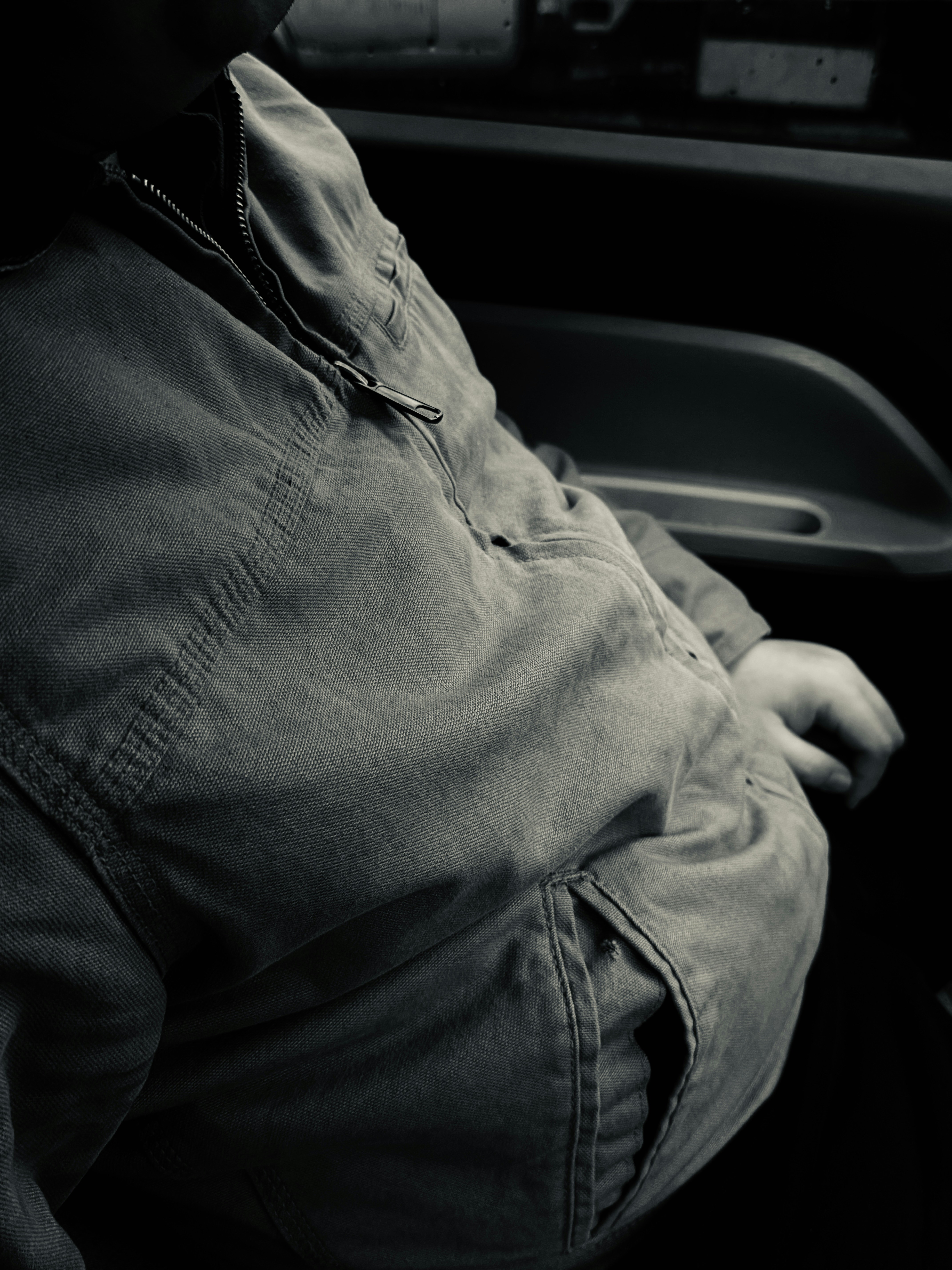 Personne en veste en jean à l’intérieur d’un véhicule.