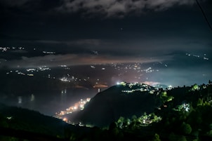City lights twinkle on distant hills at night.