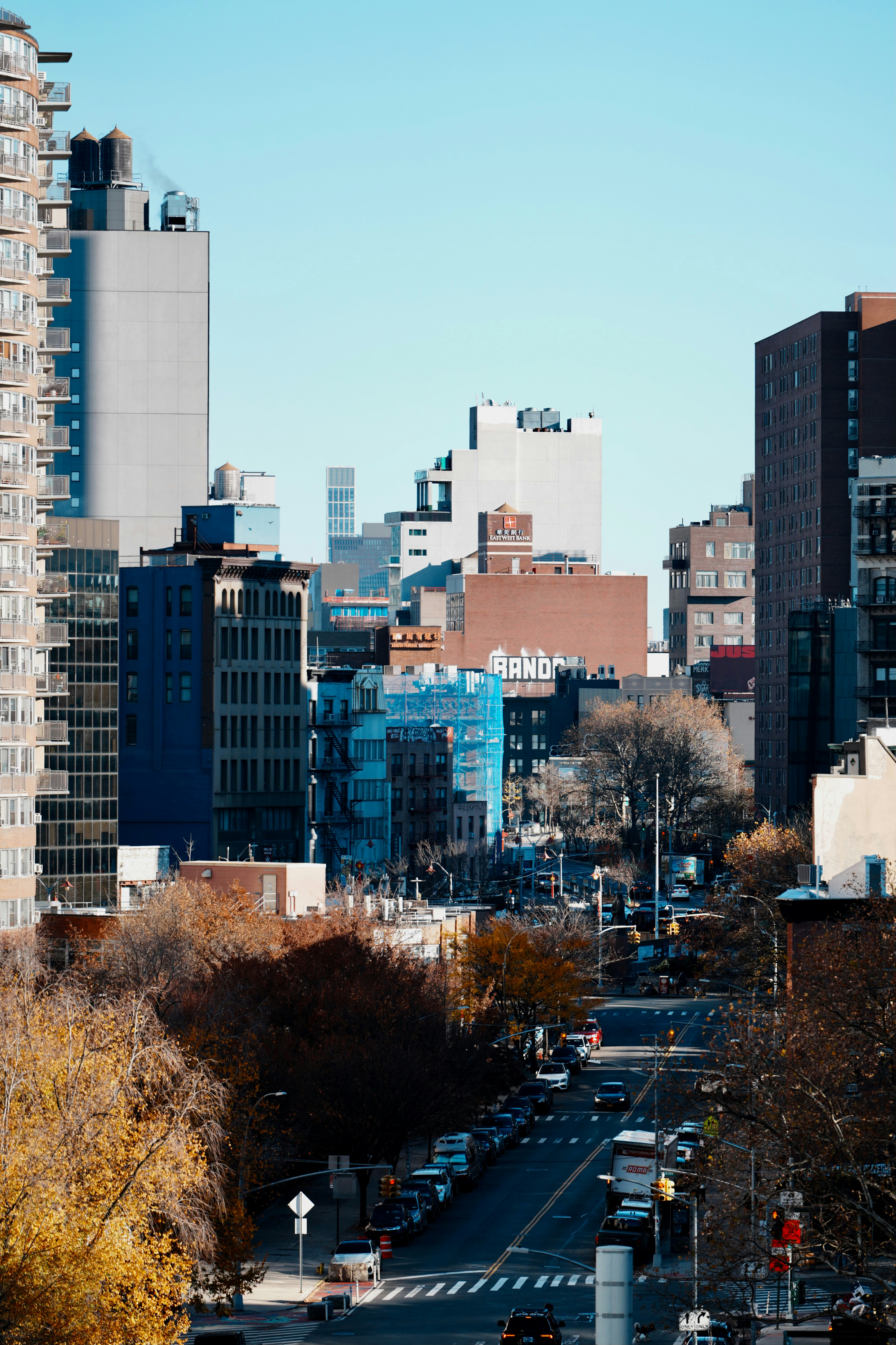 City street lined with buildings and parked cars.