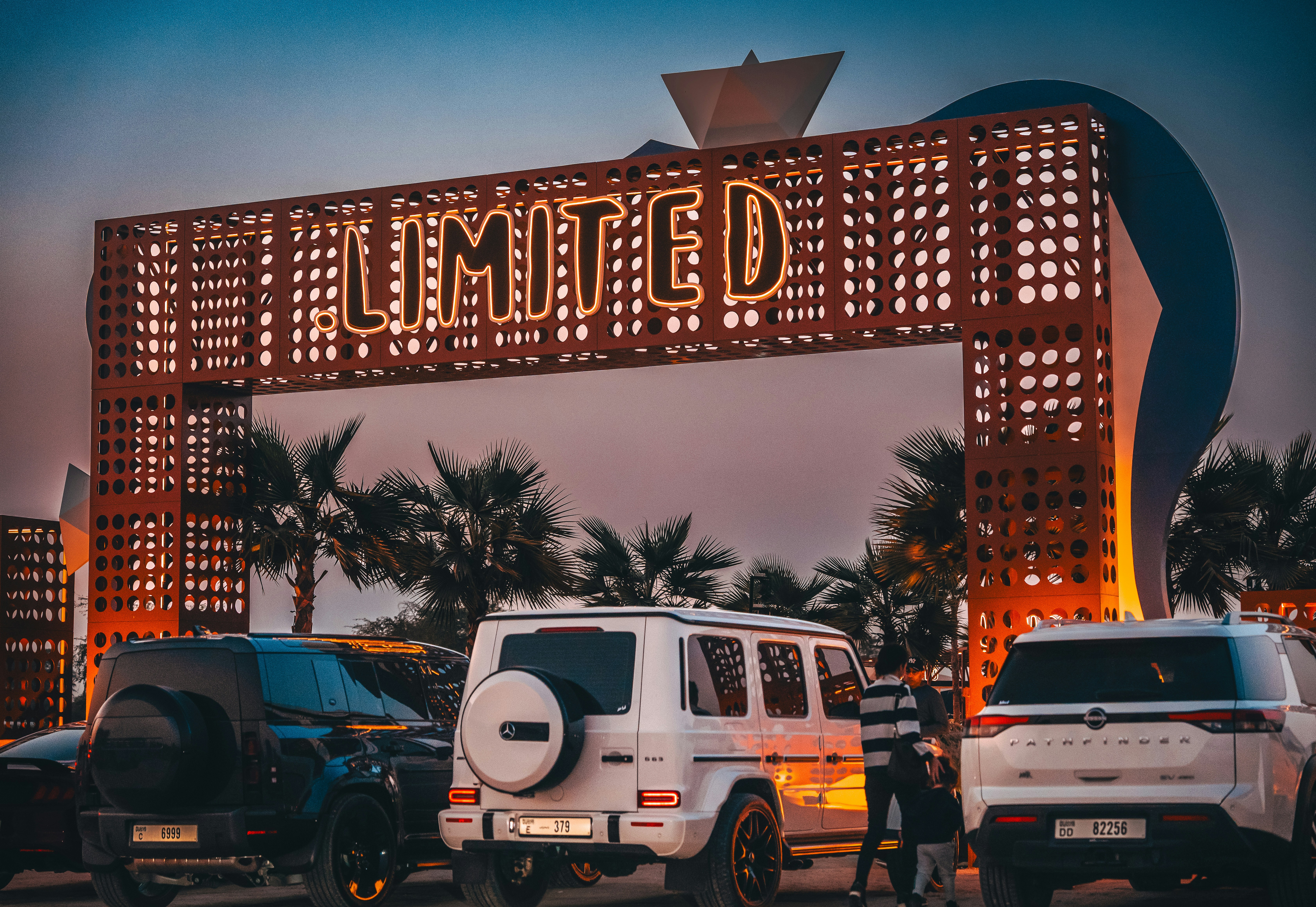 Cars parked under a large illuminated sign