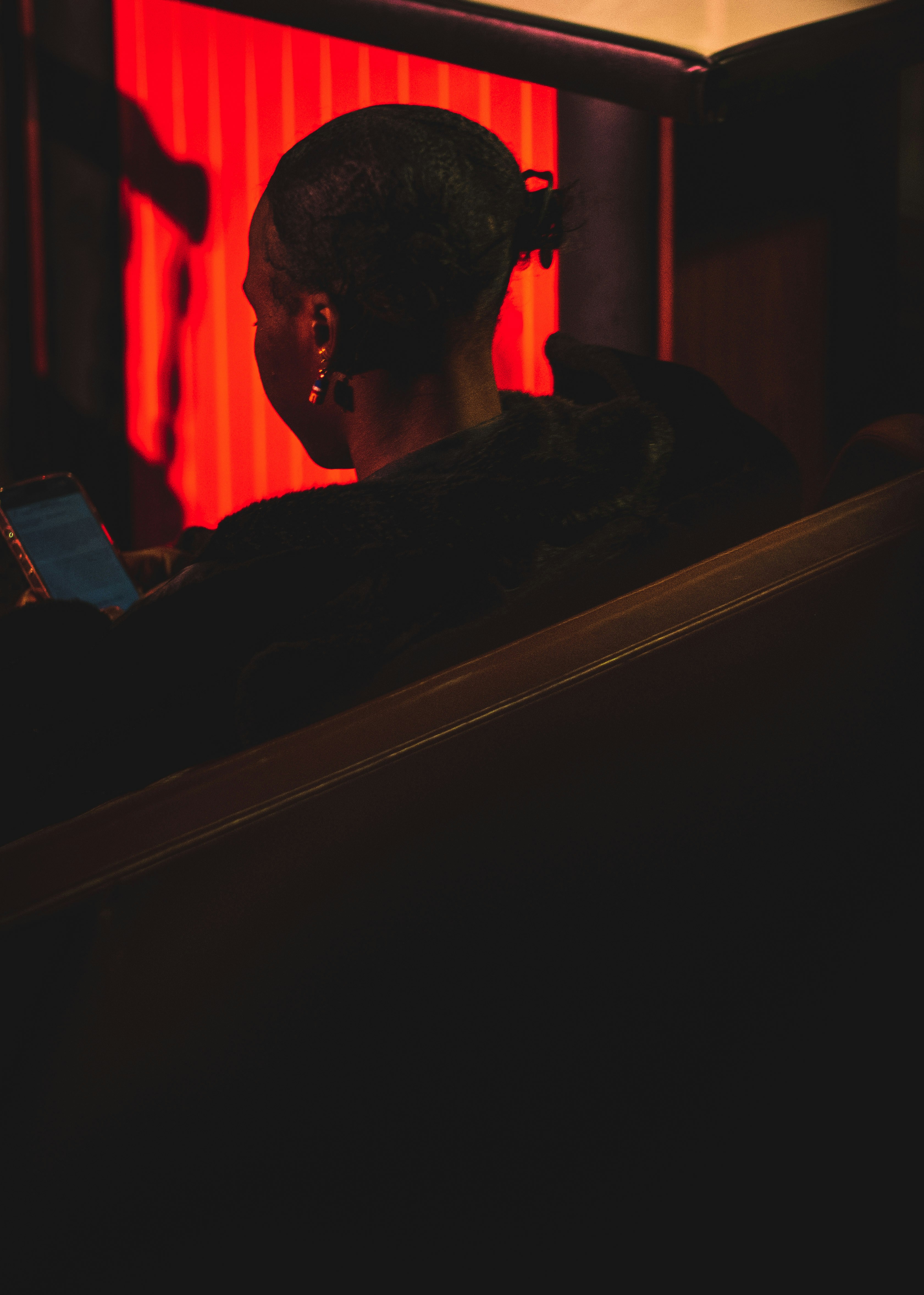 Woman in dark room looking at phone