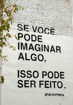 Black text on white wall with inspirational quote.