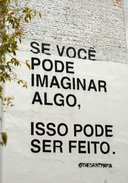 Black text on white wall with inspirational quote.