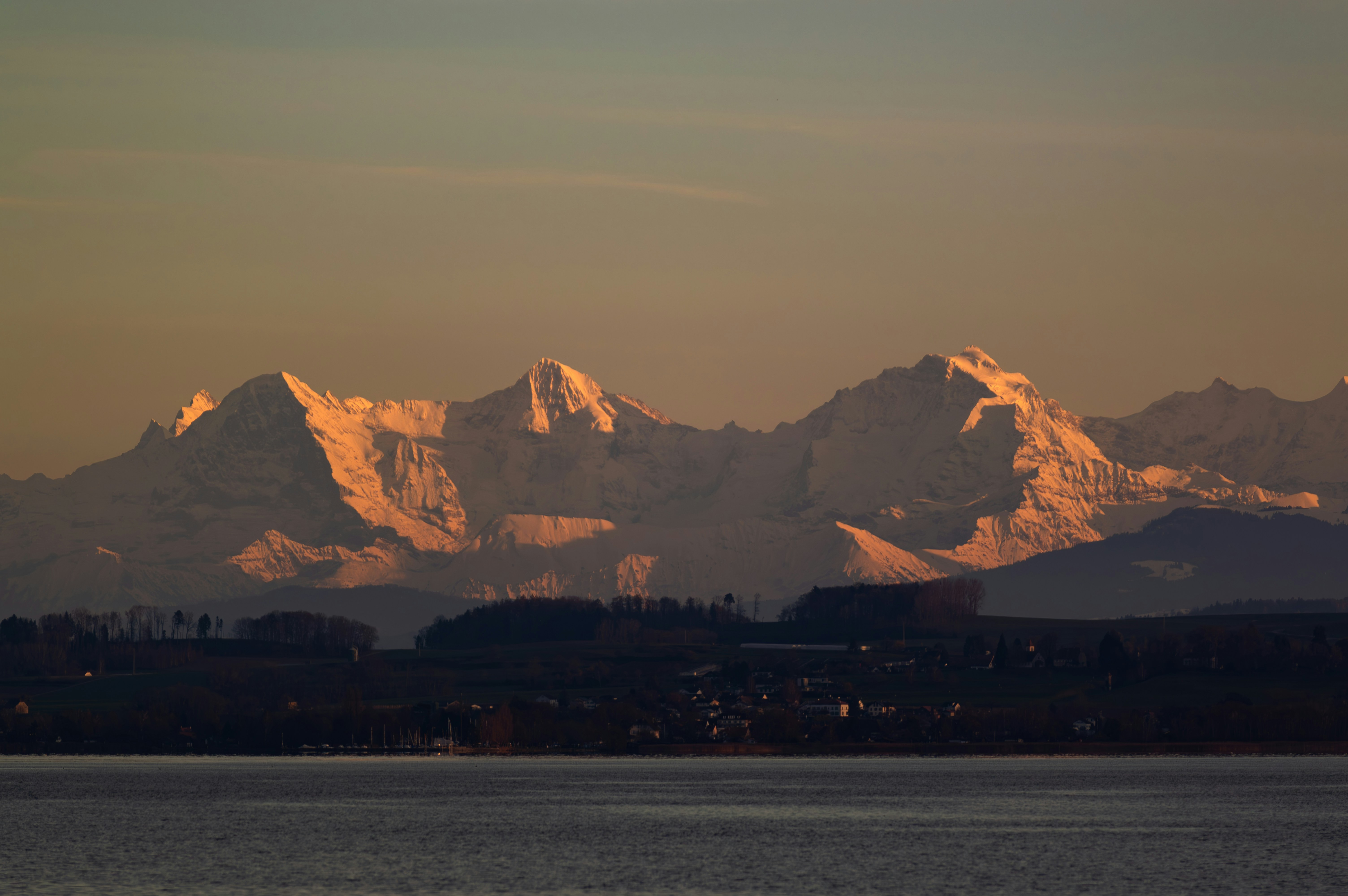 Montañas nevadas iluminadas por la cálida luz del atardecer.