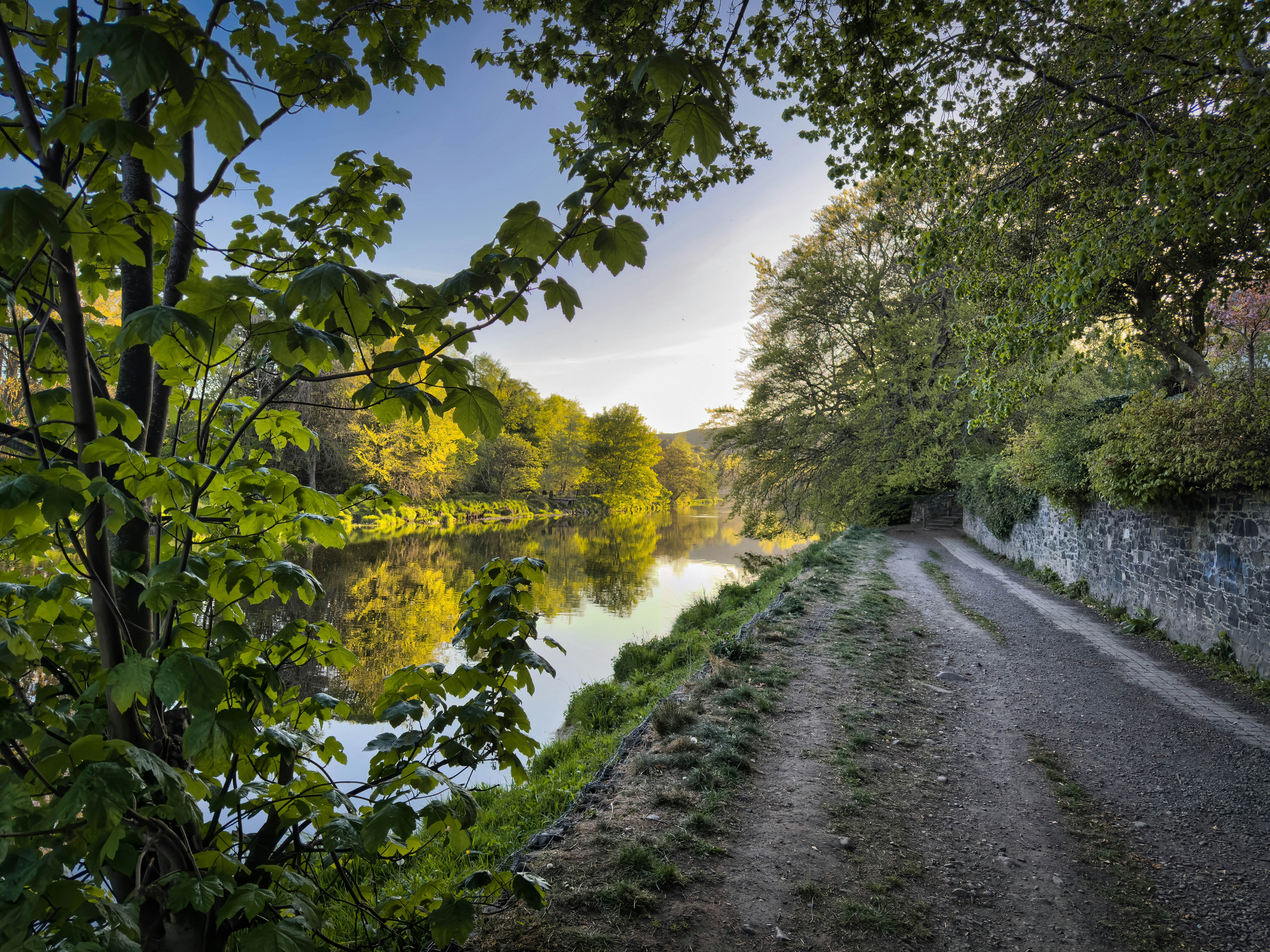 A scenic canal path beside trees and water