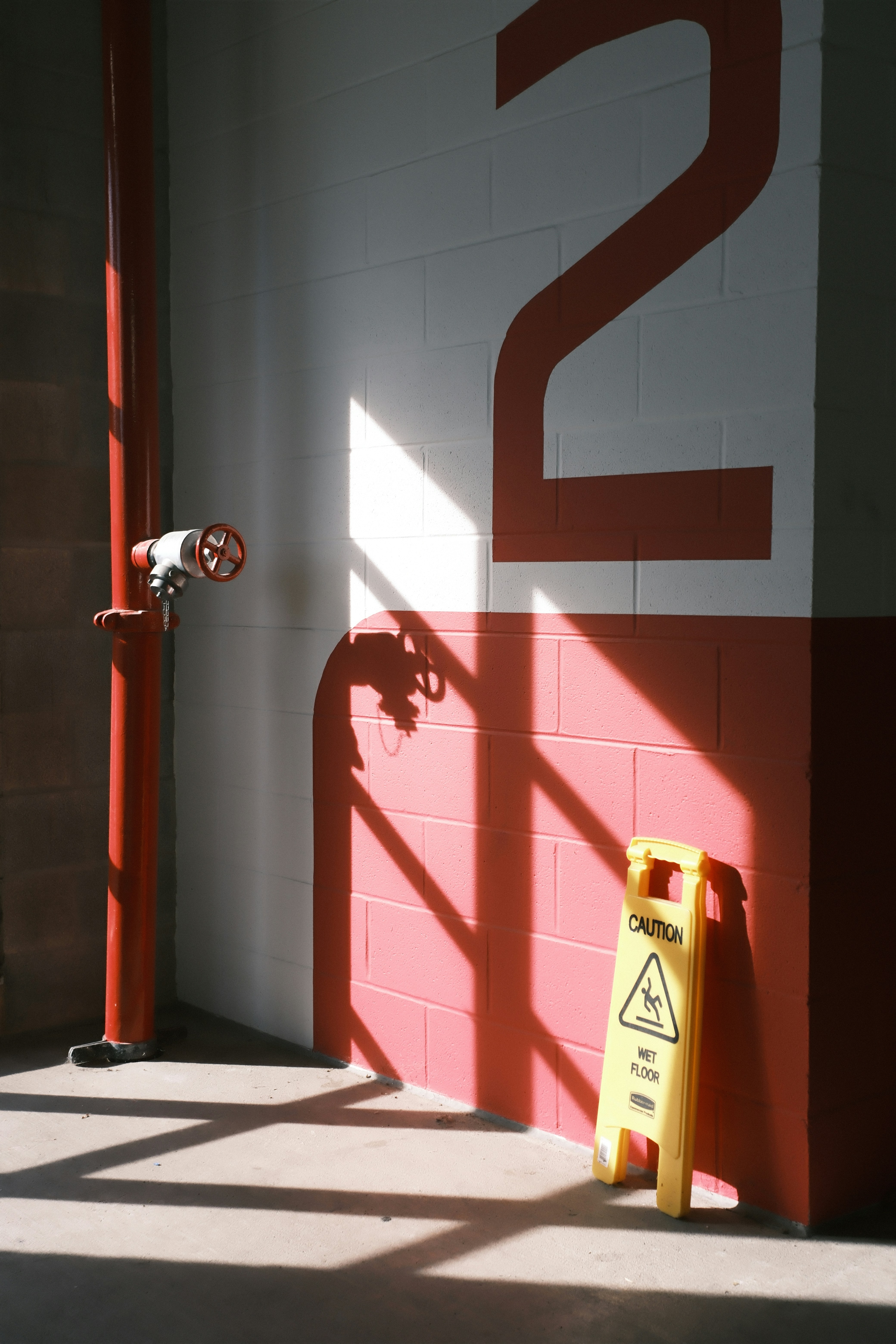 Caution wet floor sign next to pipe.