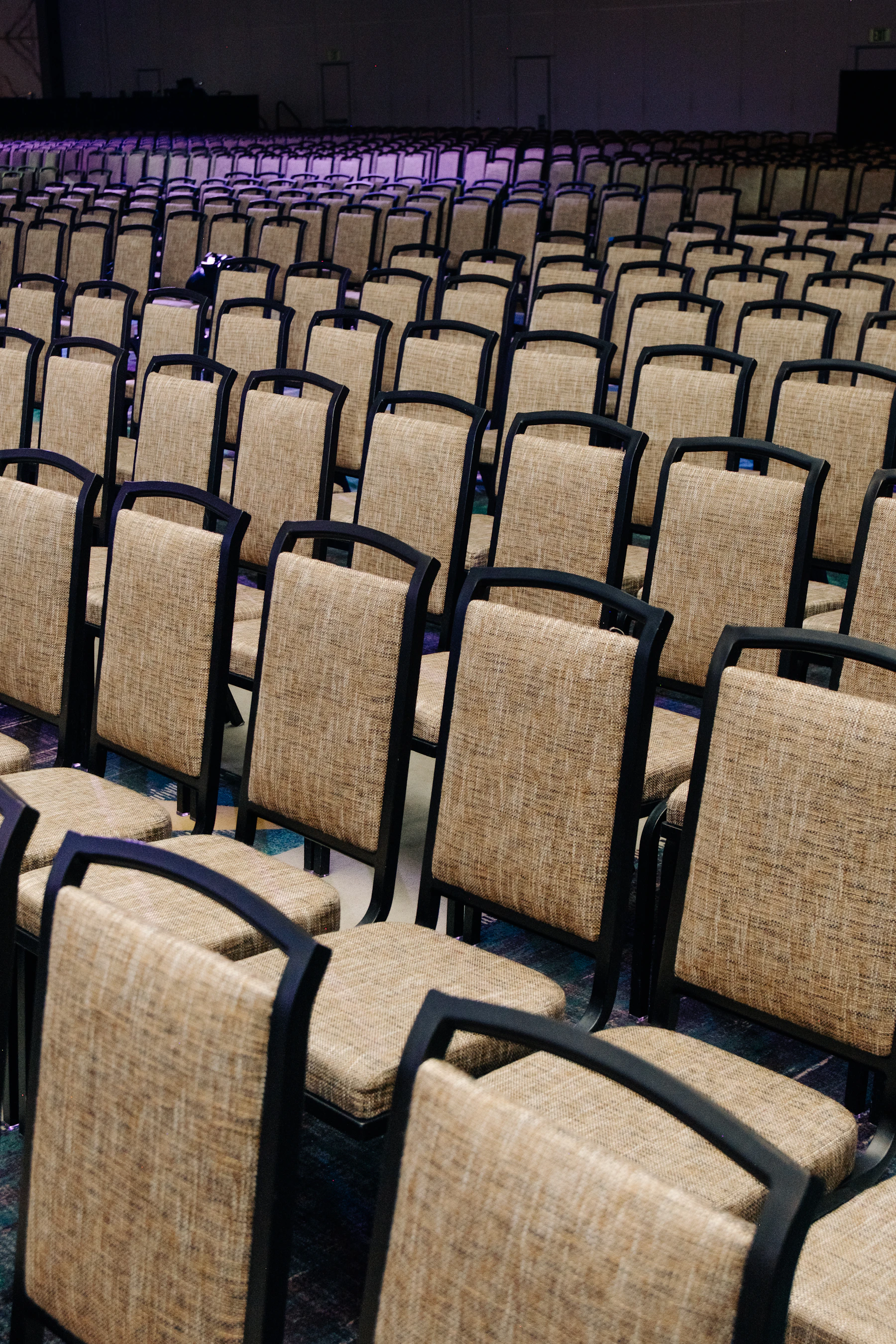 Rows of banquet chairs set out in an empty hall before the event