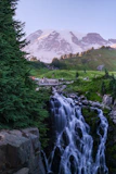 Waterfall cascading down rocks with snow-capped mountain background