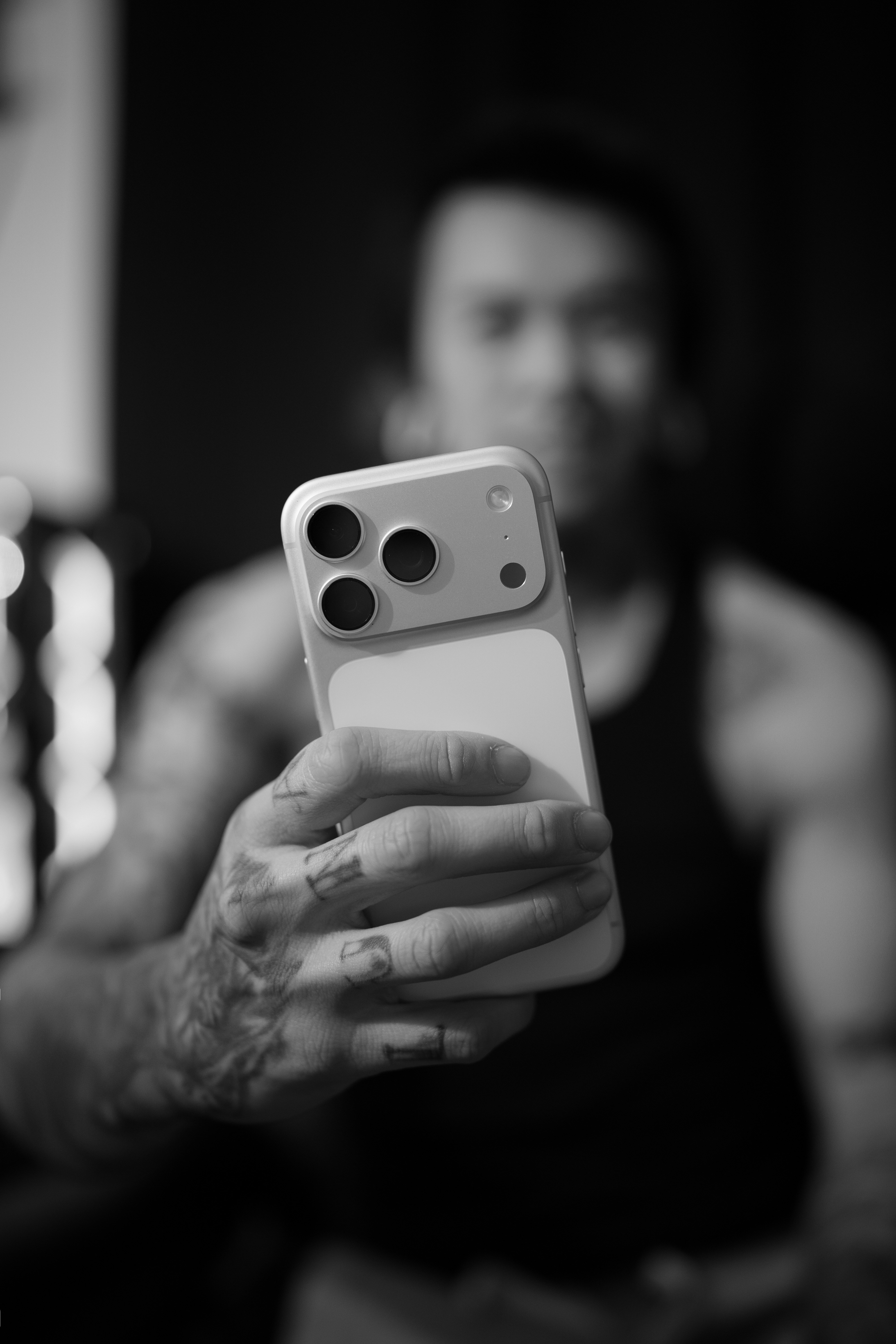 Hombre sosteniendo un smartphone en blanco y negro