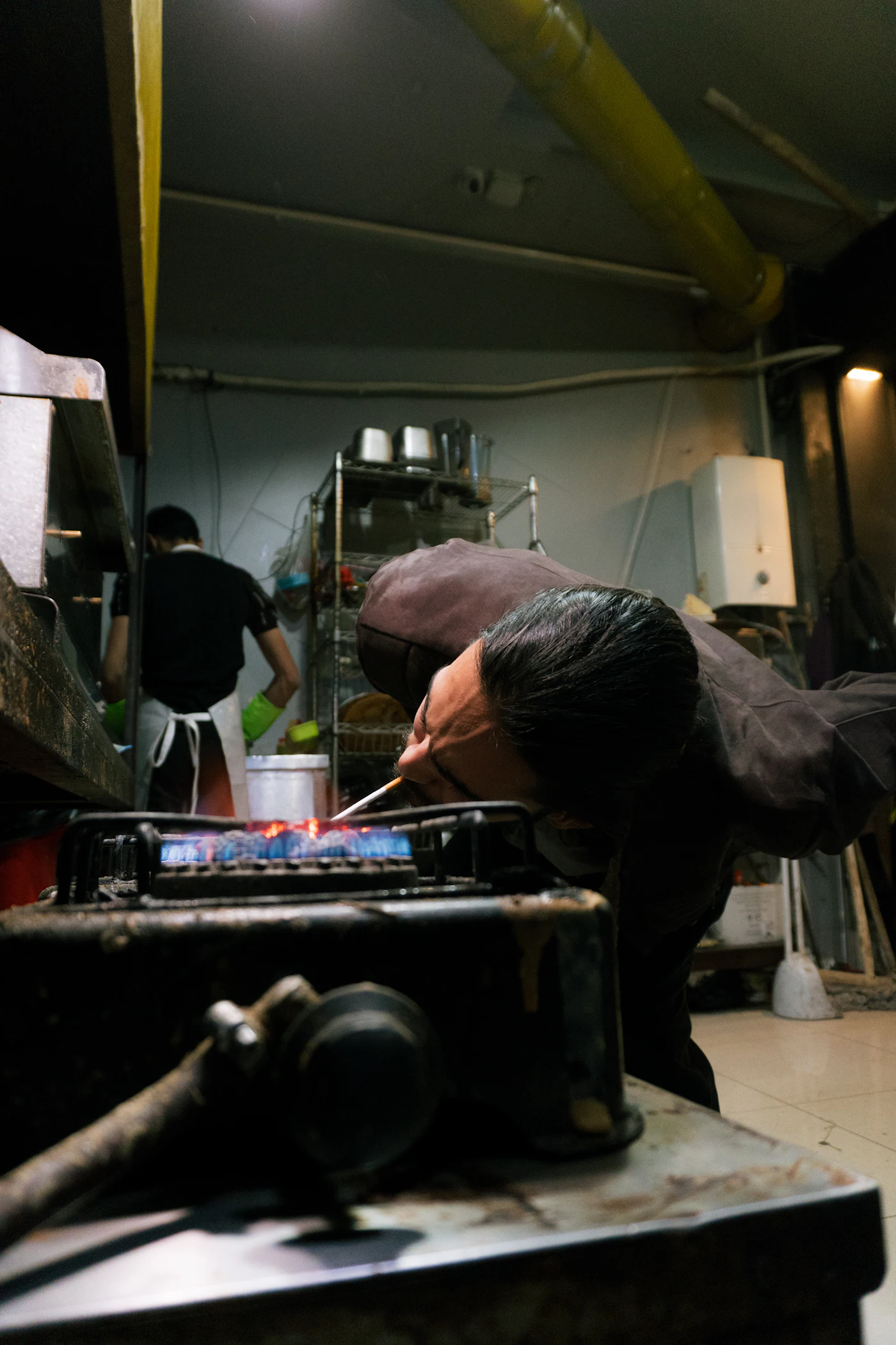 Technician inspecting a gas flame and cooking equipment