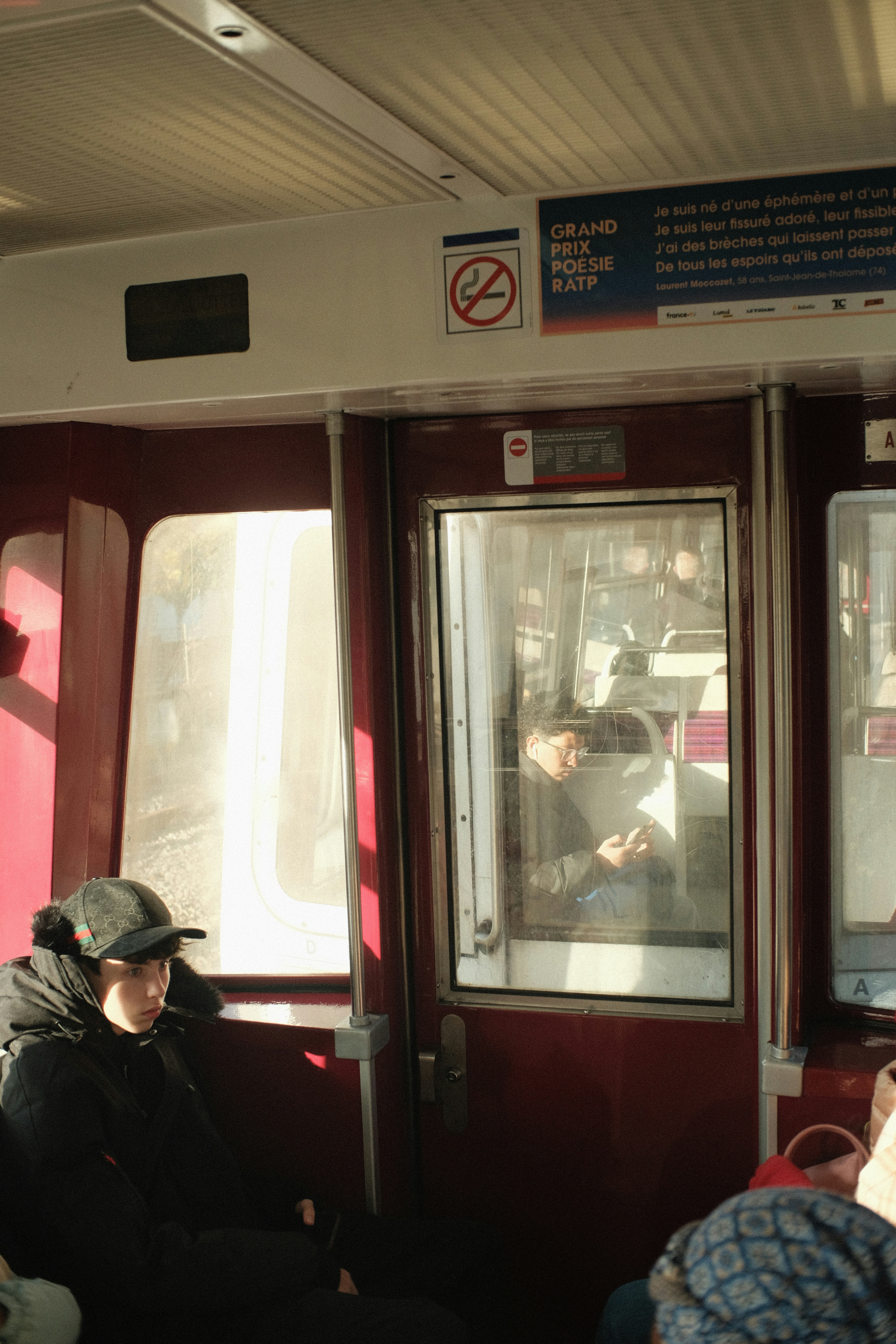 Person wearing a cap inside a train