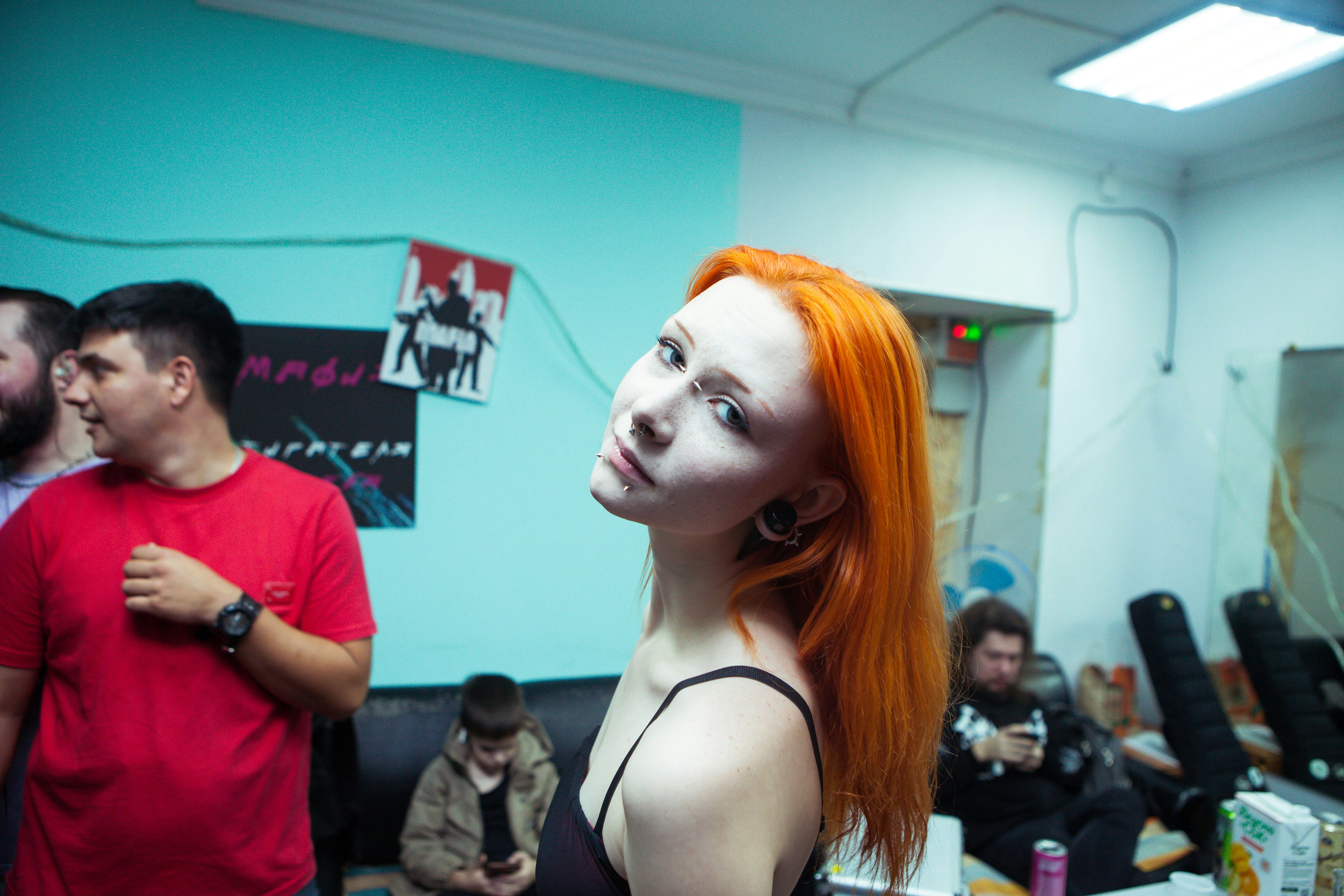 Young woman with bright orange hair looking at camera