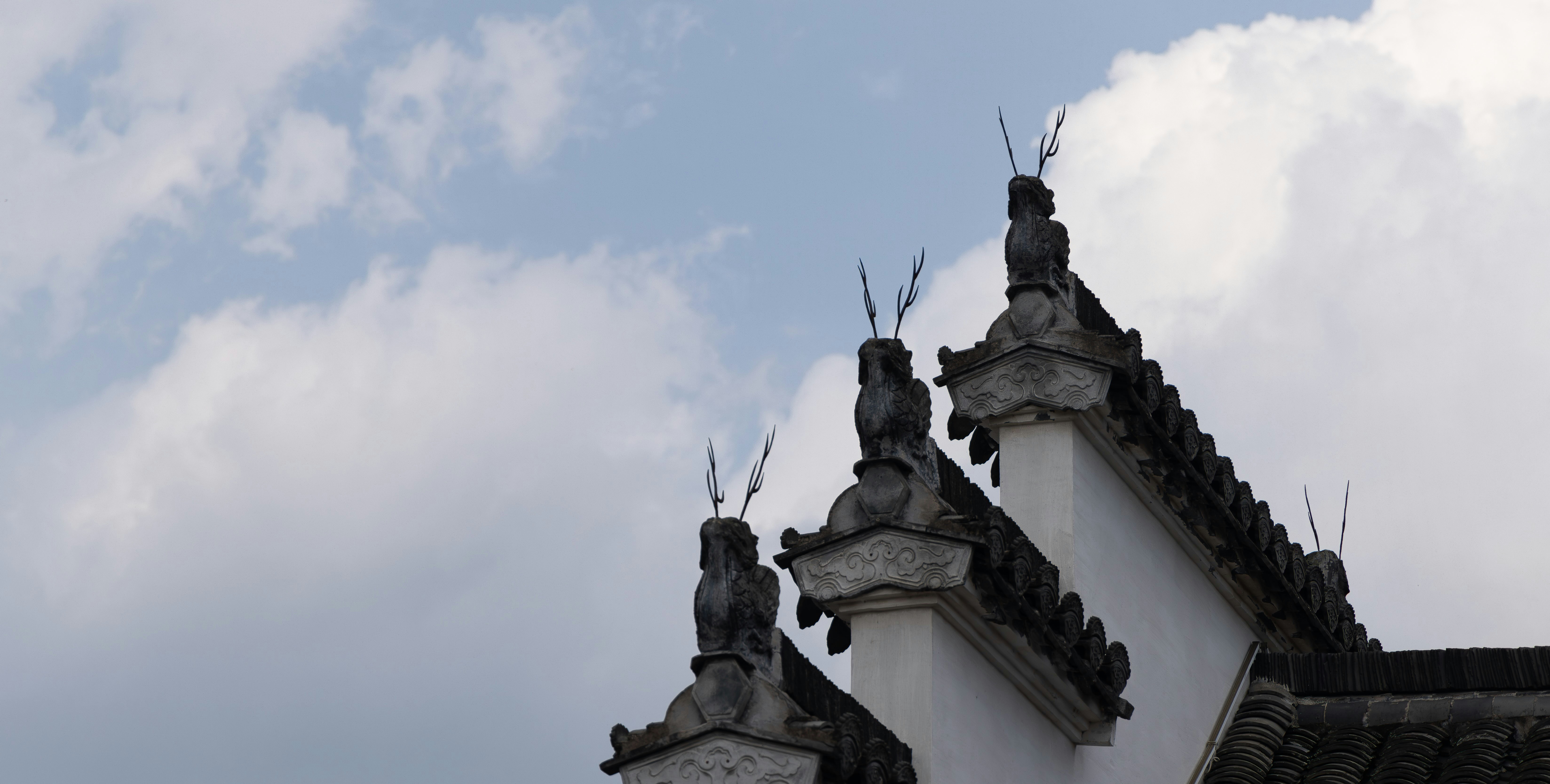 Ornate roof details against a cloudy sky