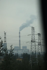 Industrial power plant with smoking chimney and towers