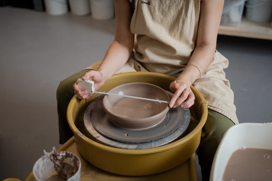 Participante concentrée au tour dans un atelier de céramique
