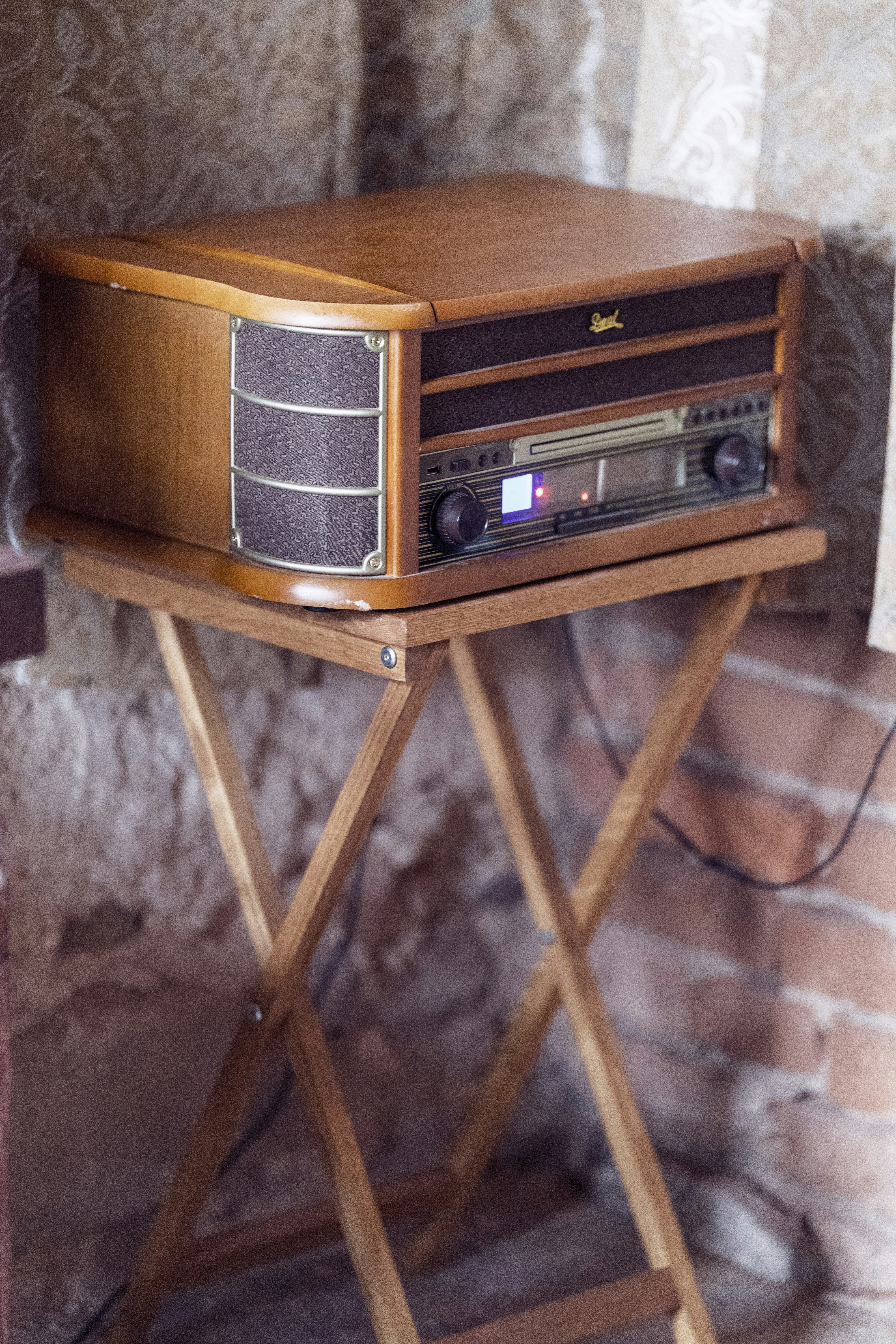 Vintage wooden record player on a folding table.