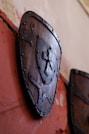 Wooden shield with metal cross emblem displayed