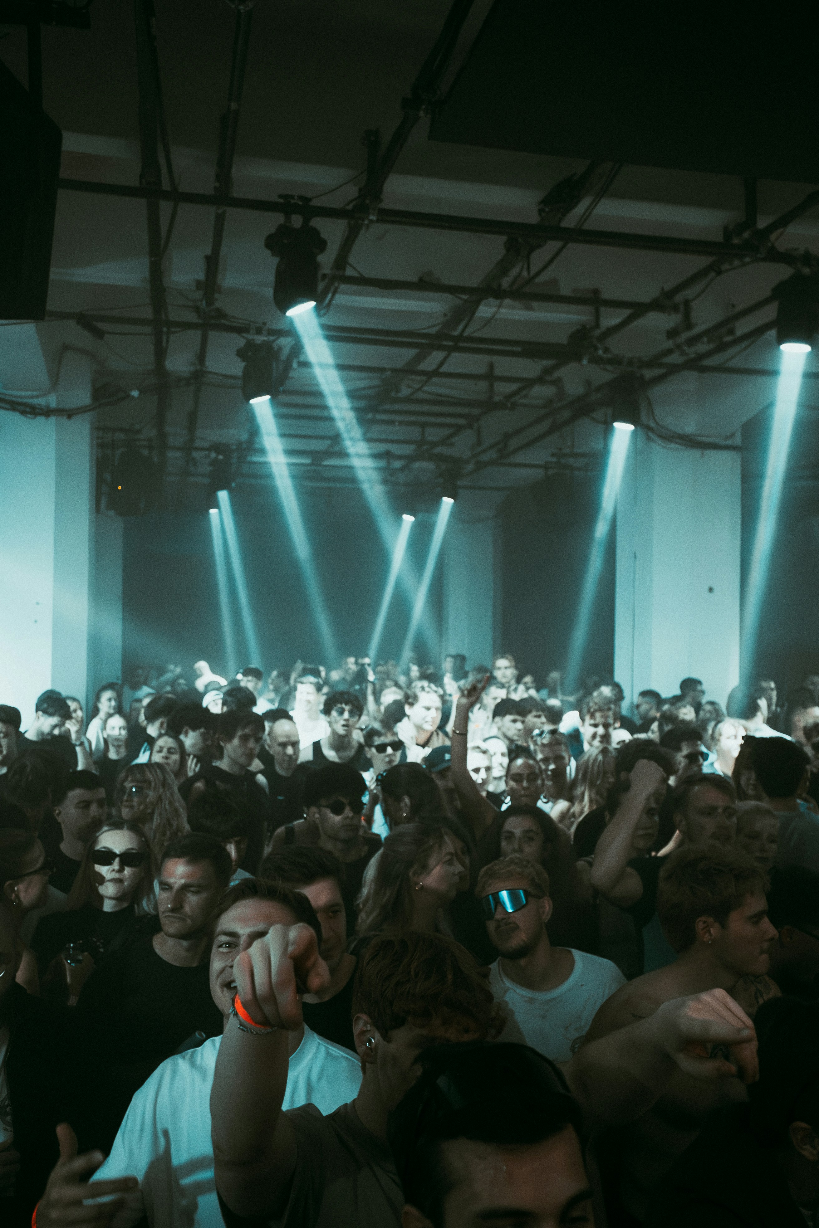 Crowd dancing under blue lights at a concert
