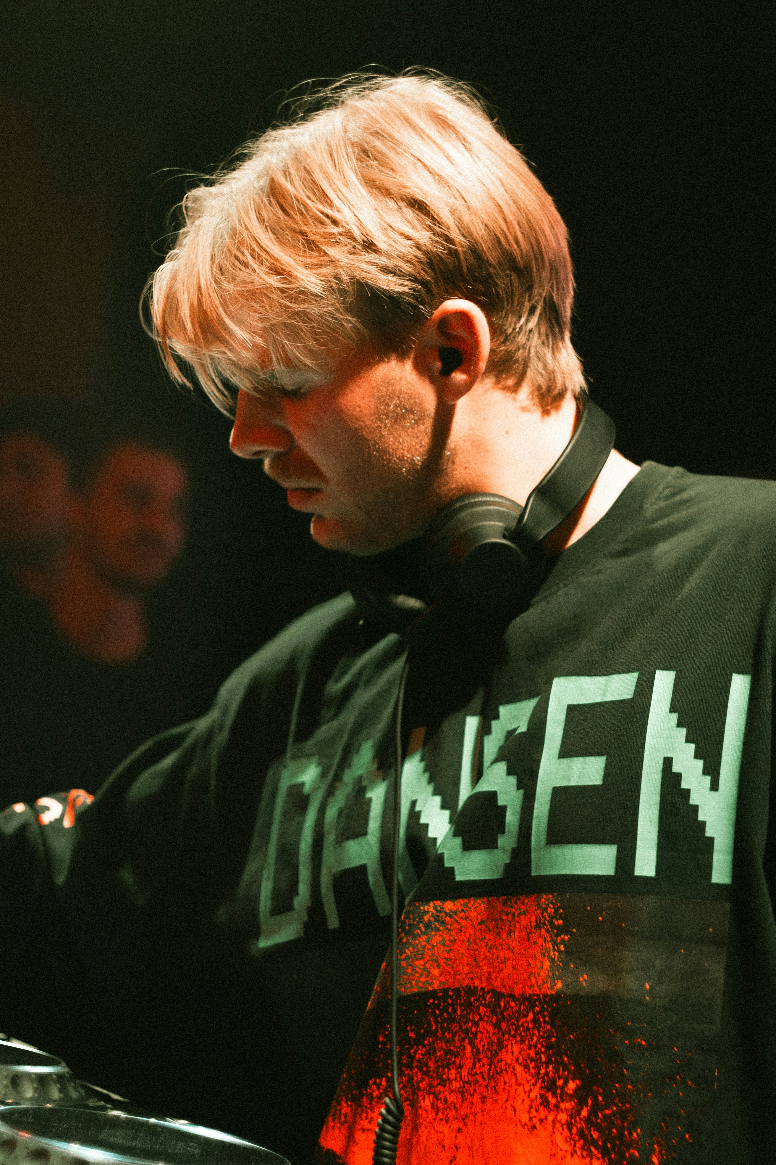 DJ trägt Kopfhörer und ein aufgedrucktes T-Shirt