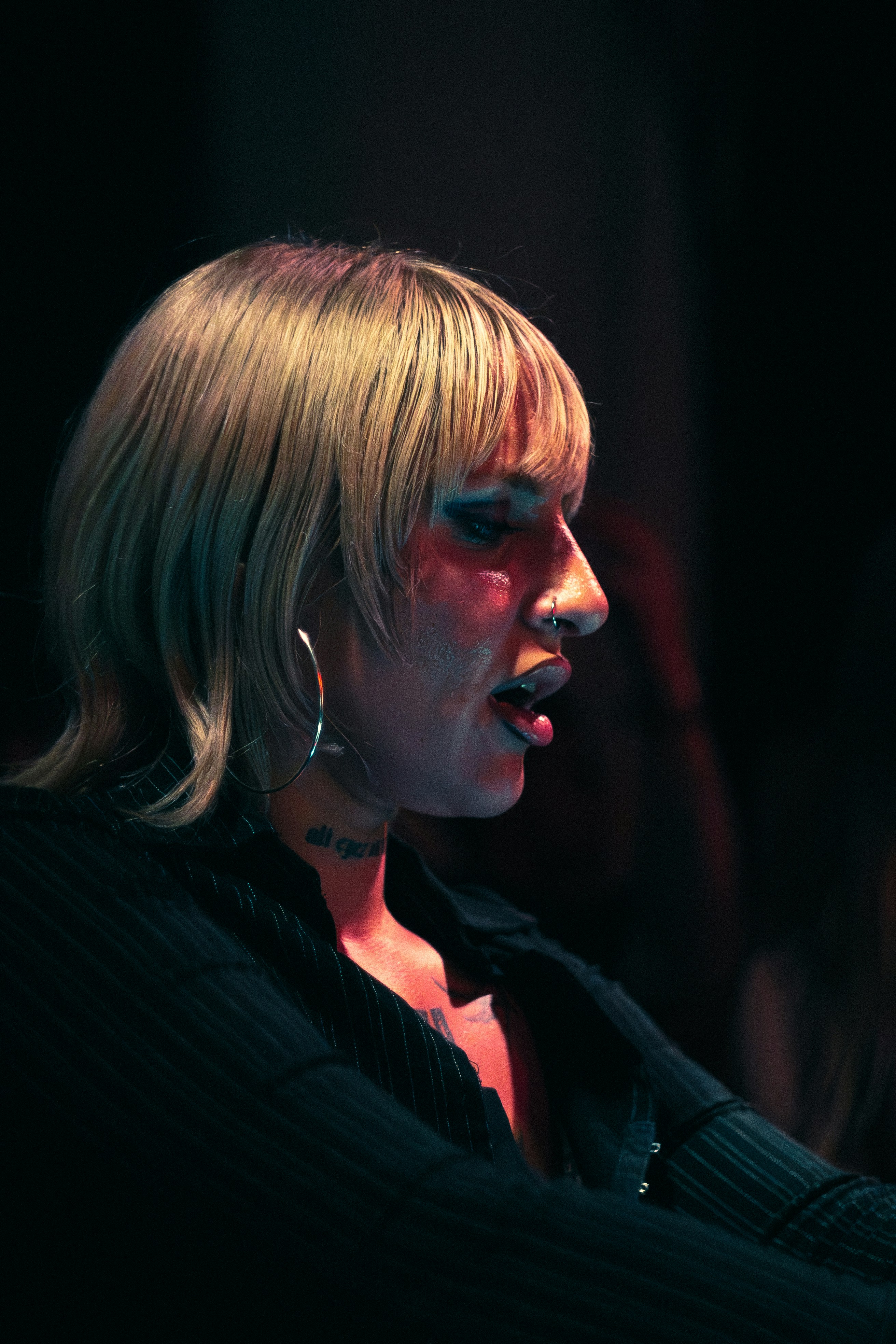 Woman with blonde hair and hoop earrings singing