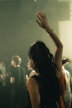 Woman dancing with arm raised at a concert.