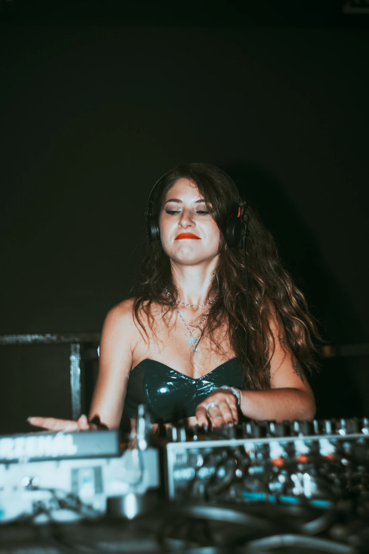 Woman DJ wearing headphones at a console