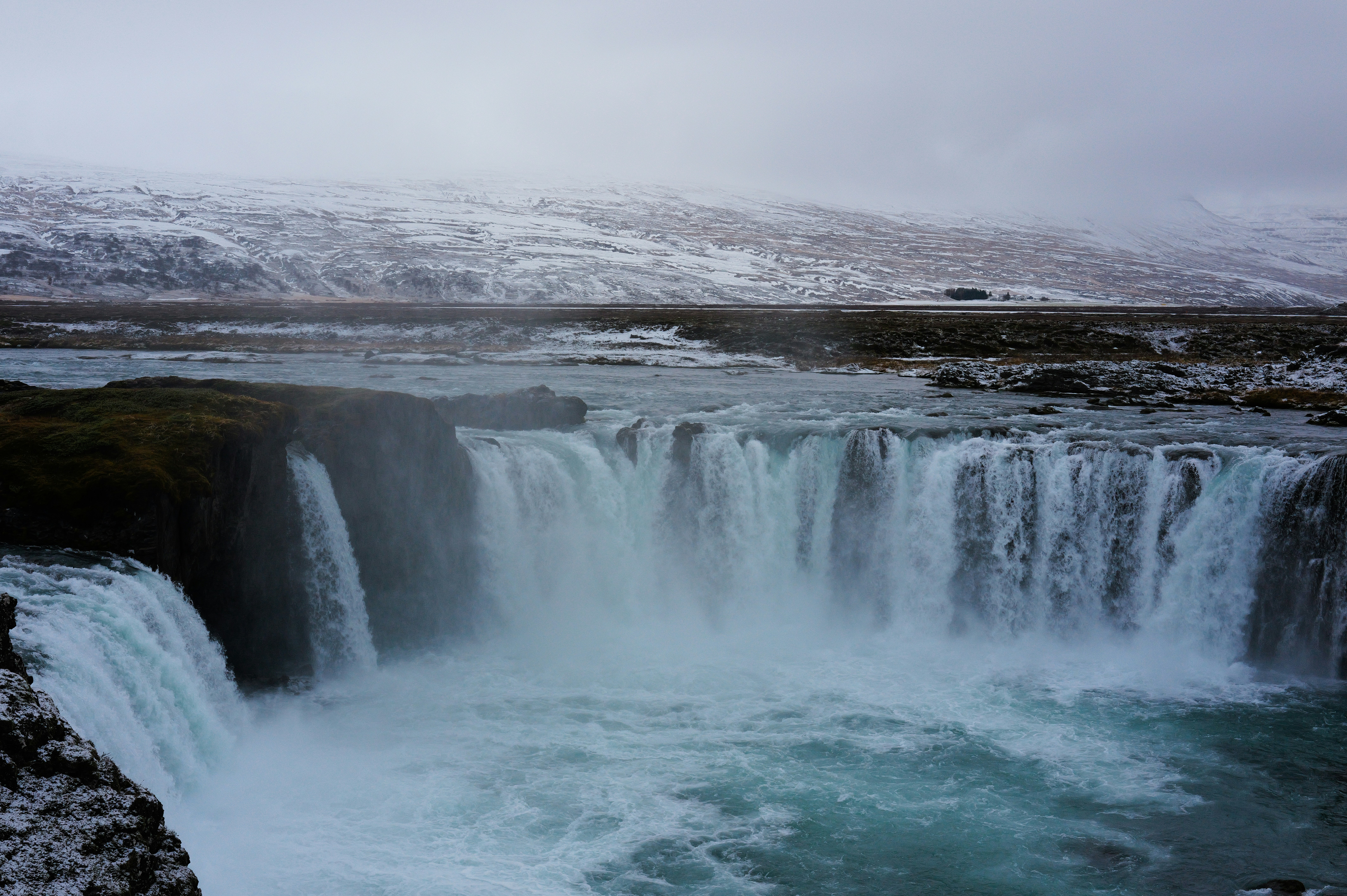 A powerful waterfall cascades into a turquoise pool