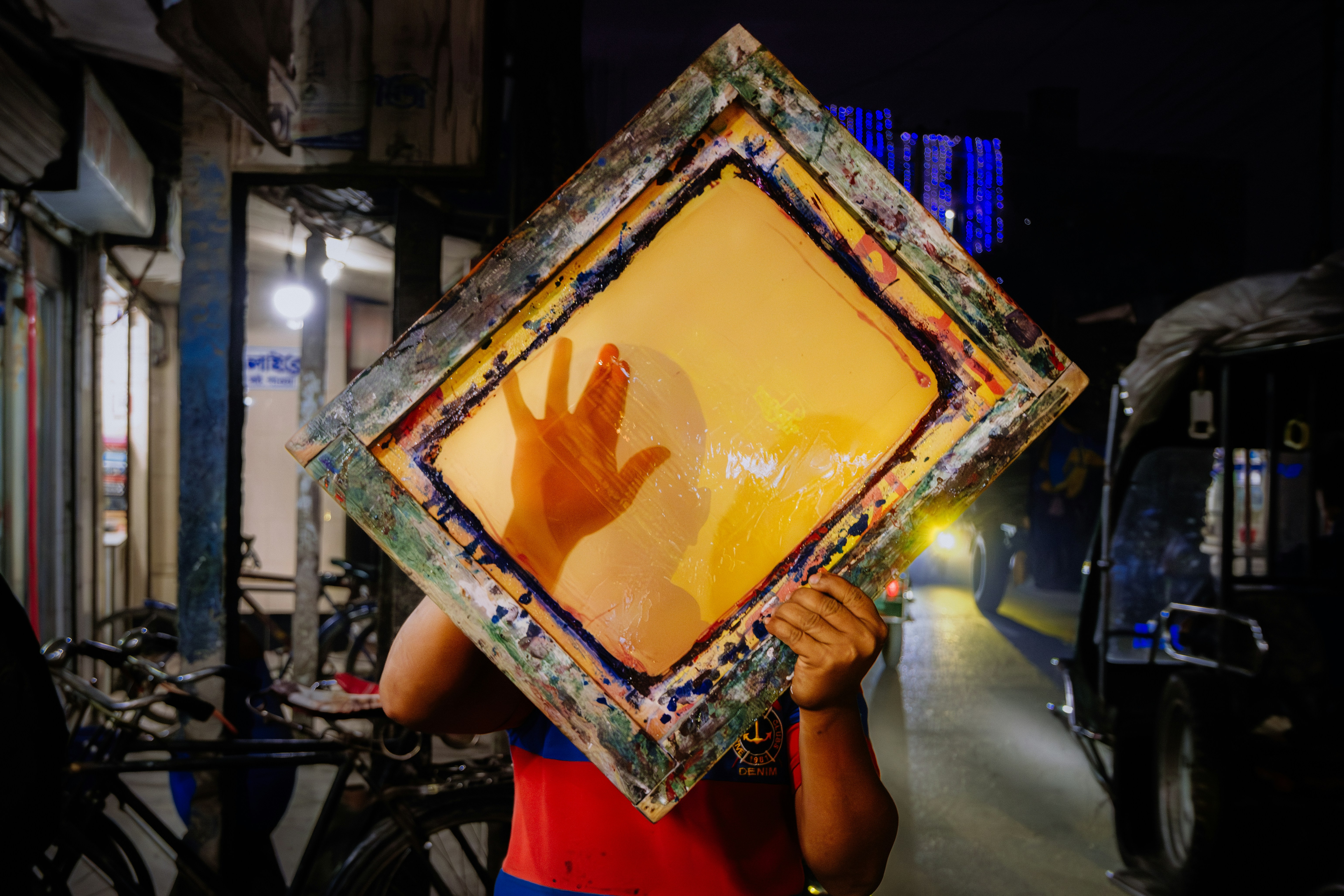 Pessoa segurando um espelho emoldurado com a mão visível.