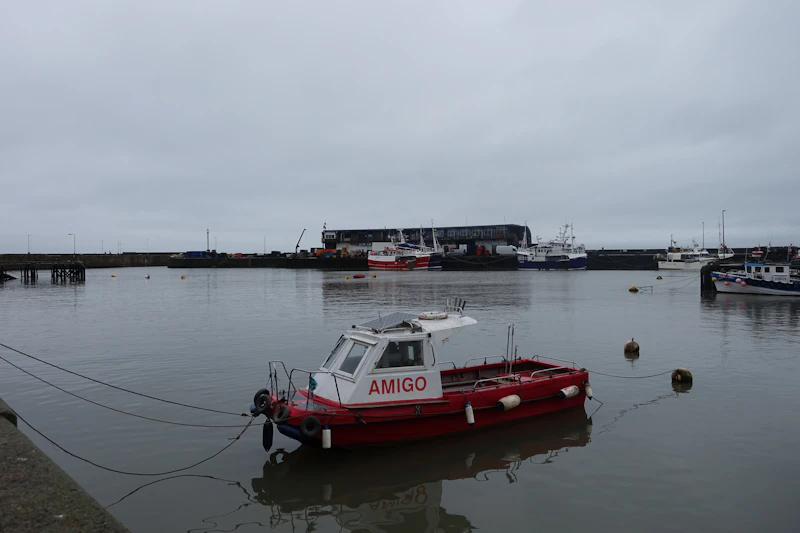 A red and white boat moored in a quiet harbor