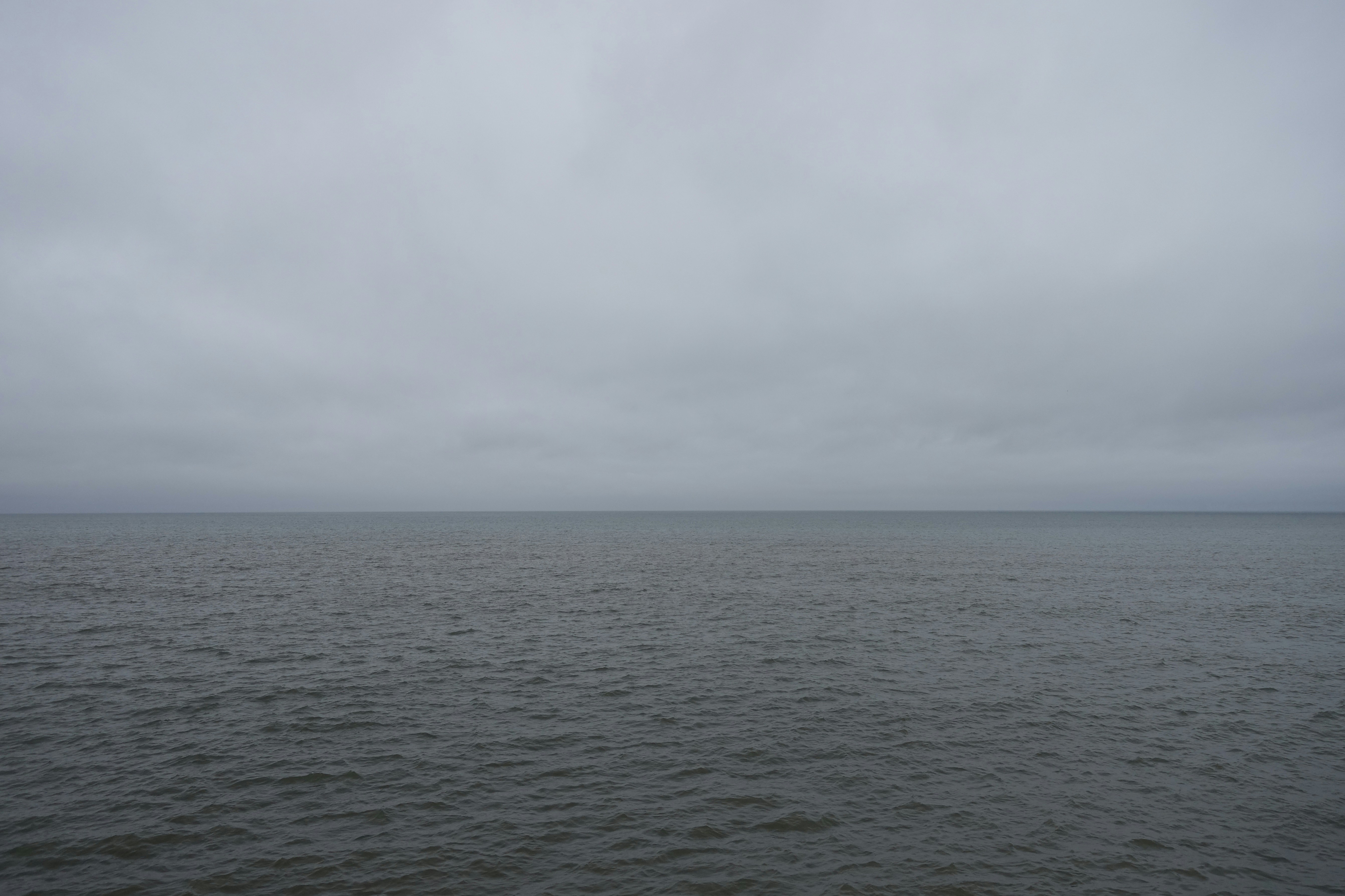 Overcast sky above a calm, dark ocean